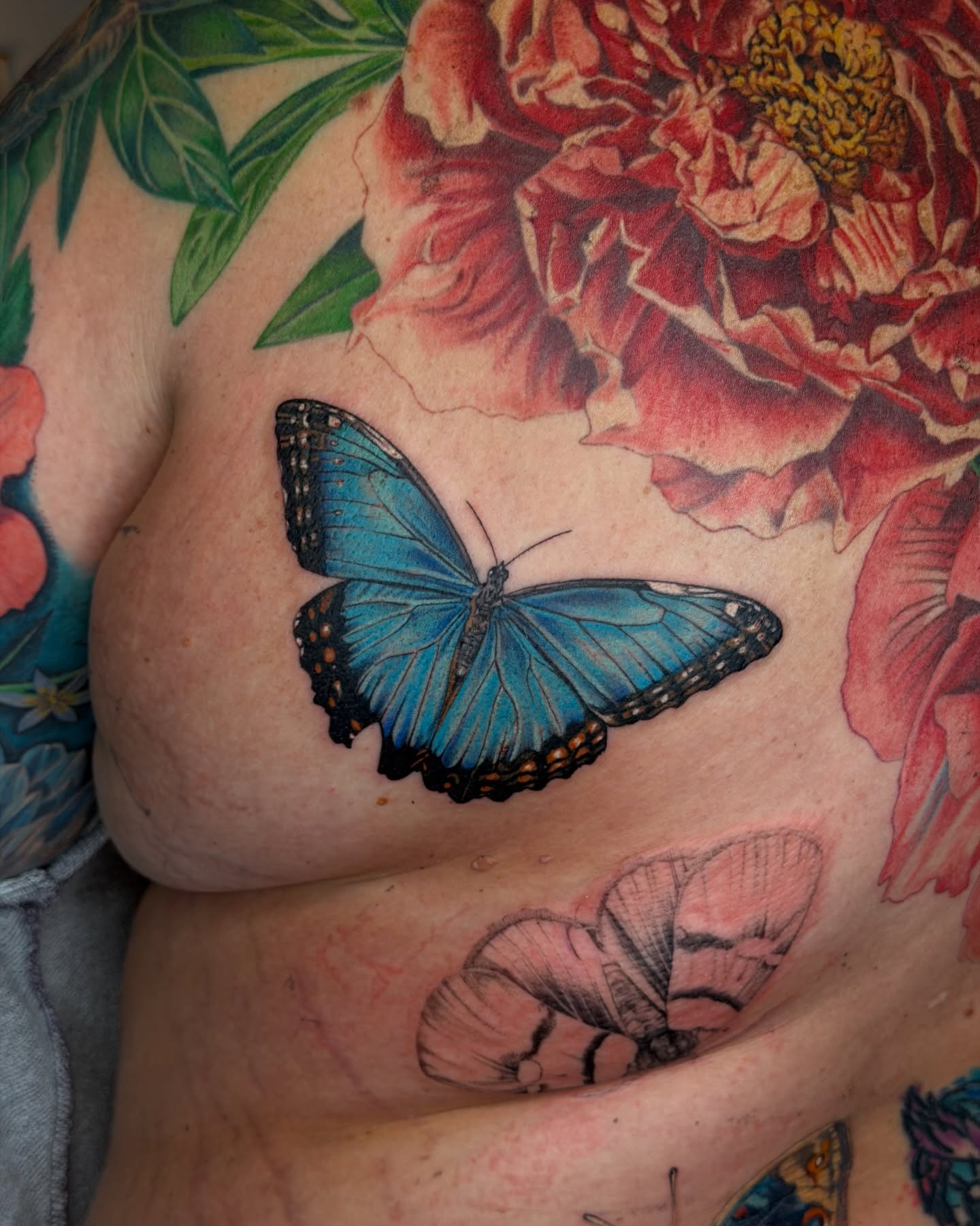 Blue butterfly realism tattoo on the chest by Jiemin Lin