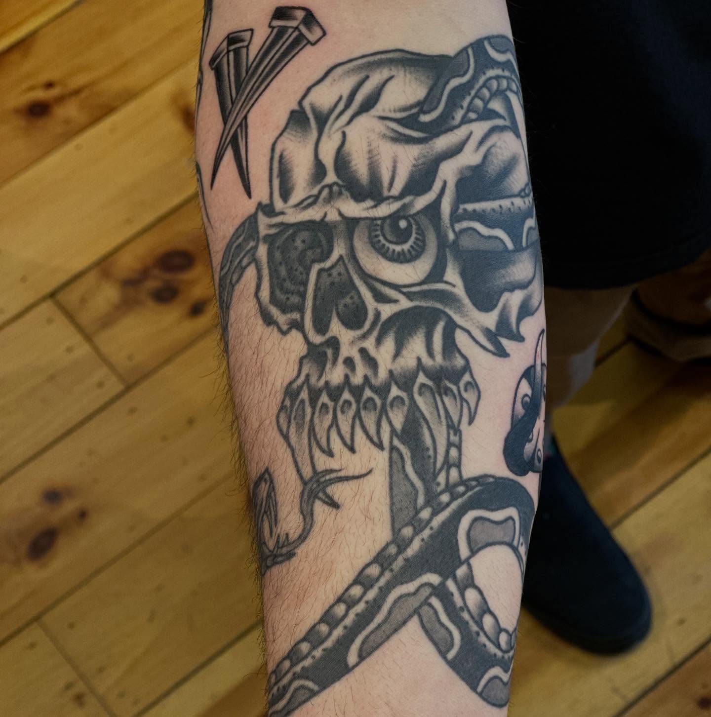 Skull with snake realism tattoo on the forearm by Dylan Curry