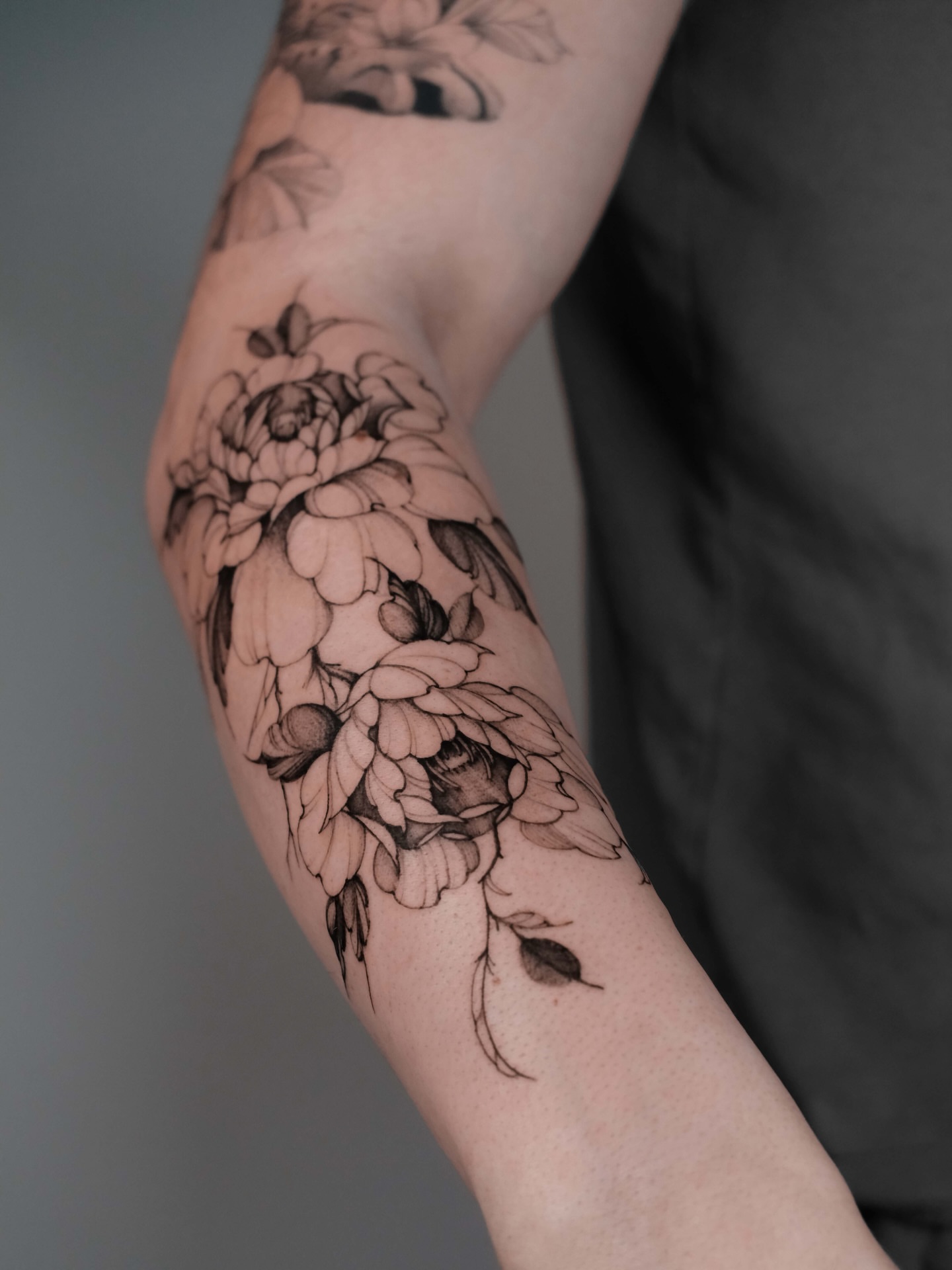Floral bouquet black and grey tattoo on the forearm by Anastasiia