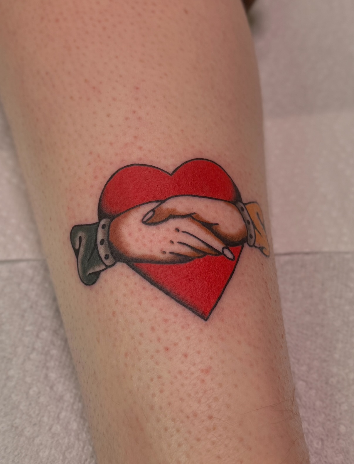 Heart with hands American traditional tattoo on the forearm by Ethan, Toledo, Ohio