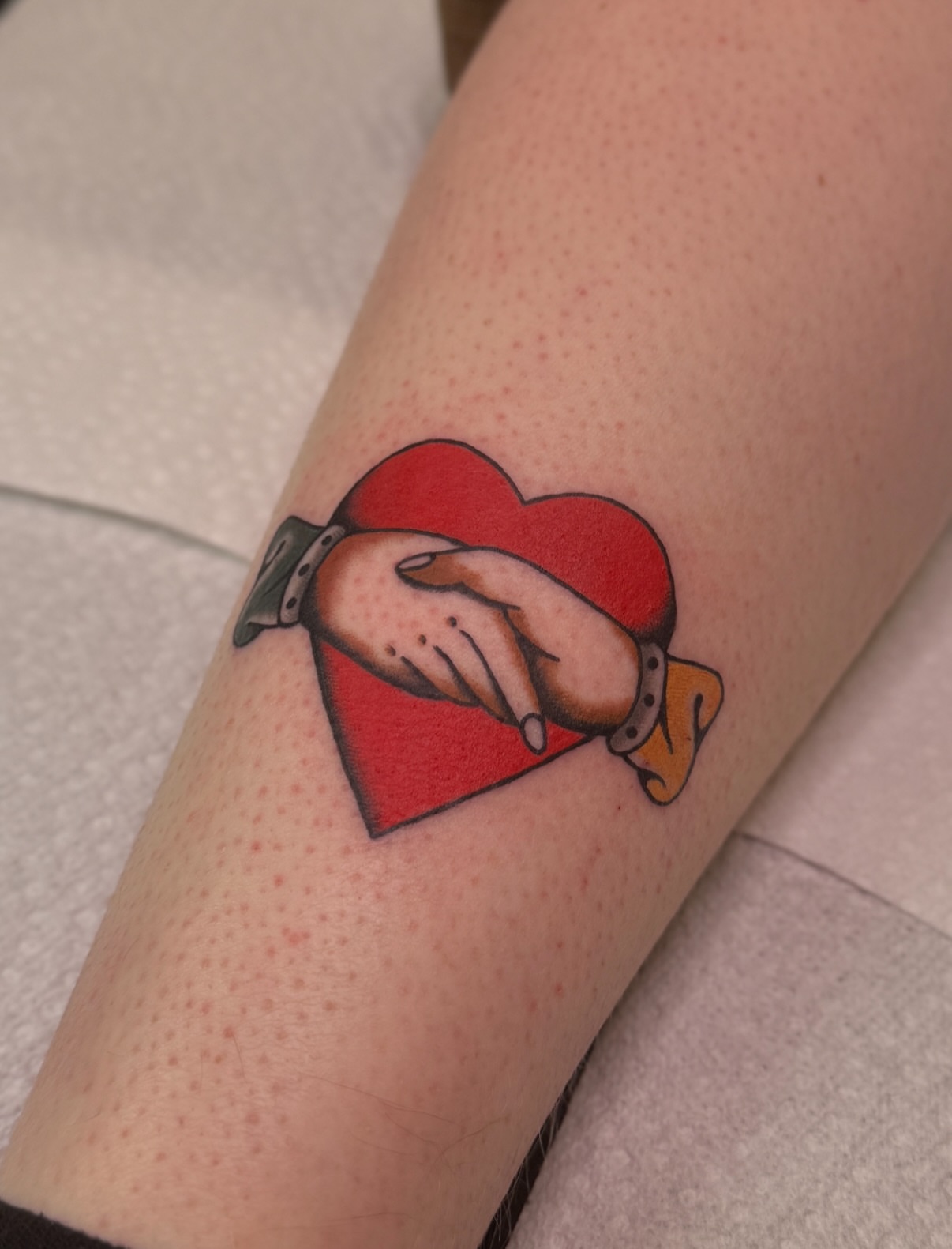 Heart and handshake American traditional tattoo on the forearm by Ethan, Toledo, Ohio