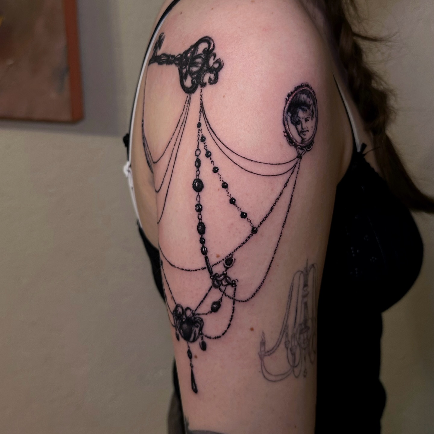 Necklace and portrait black and grey tattoo on the shoulder by kale