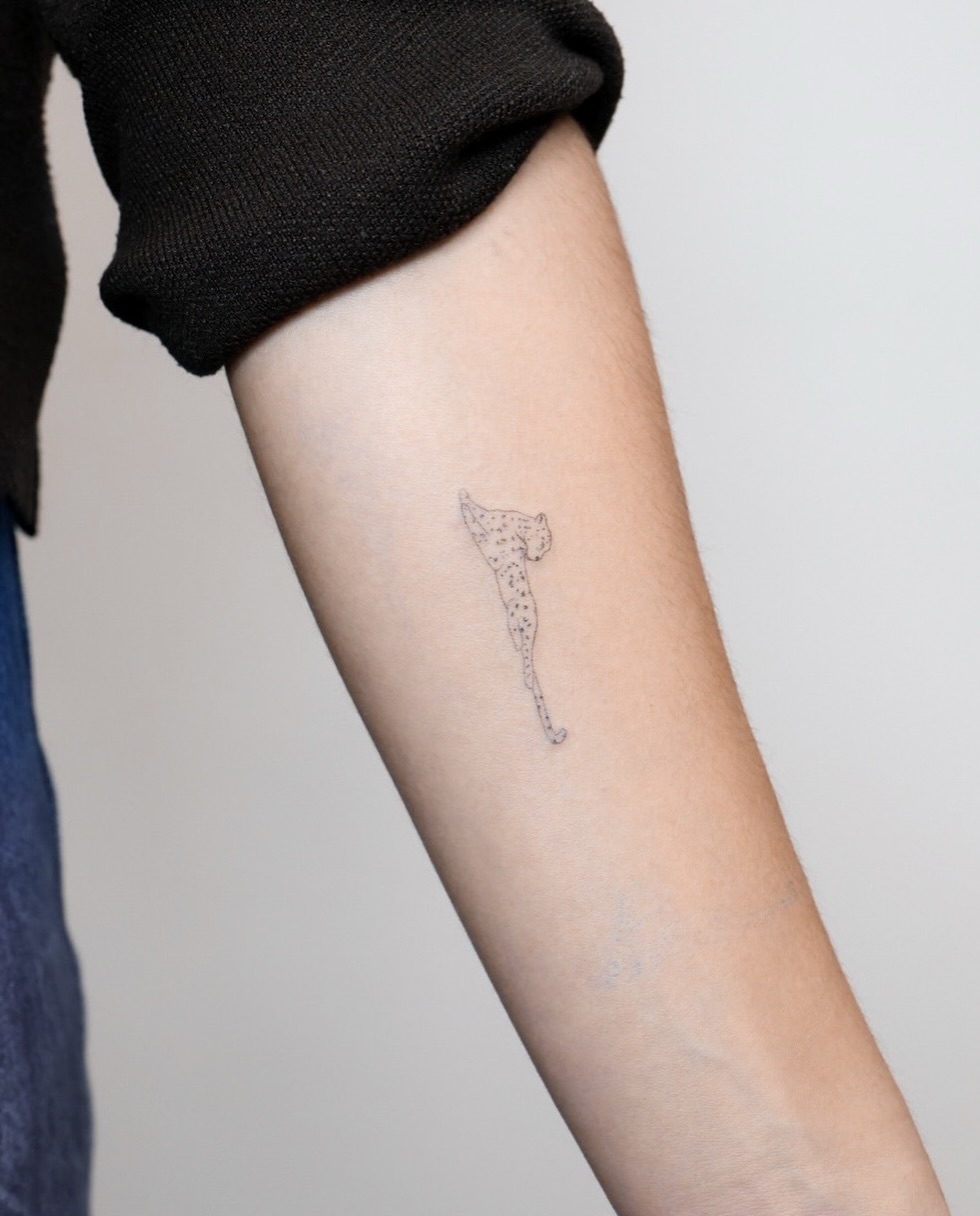 Cheetah minimalist tattoo on the forearm by Fine Line, New York, New York