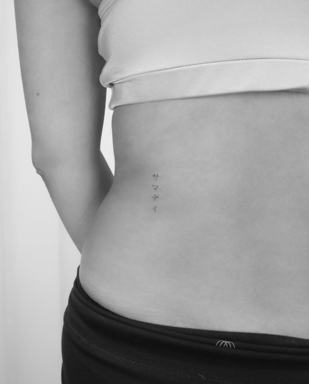 Japanese script minimalist tattoo on the torso by Fine Line, New York, New York