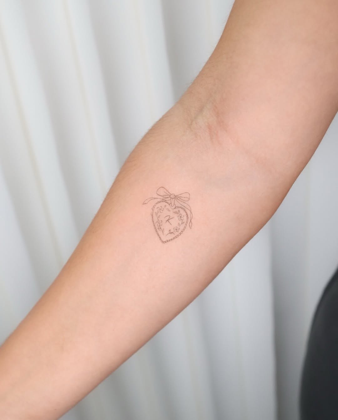 Heart with initials minimalist tattoo on the forearm by Fine Line, New York, New York