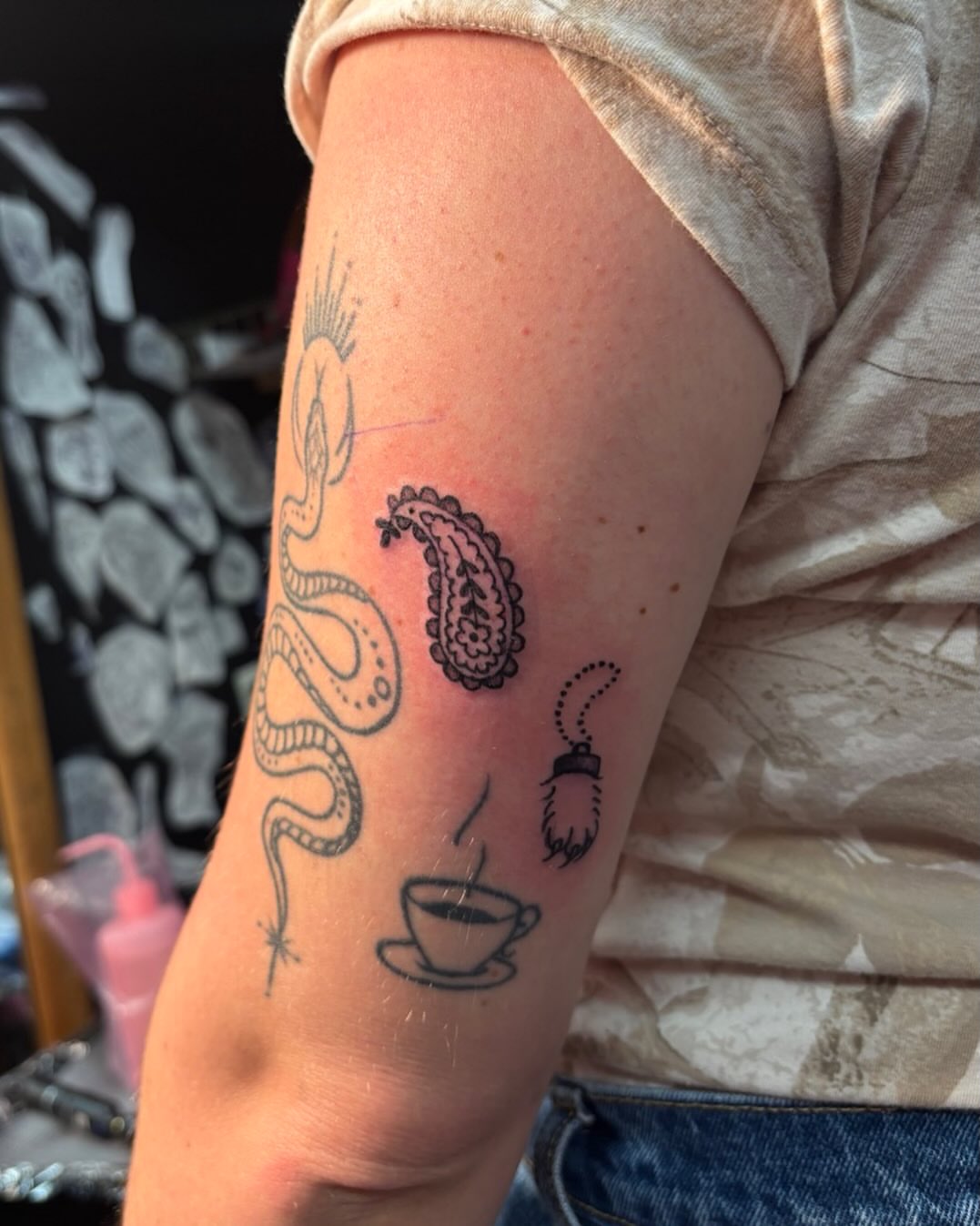 Snake and coffee cup black and grey tattoo on the forearm by Rachel