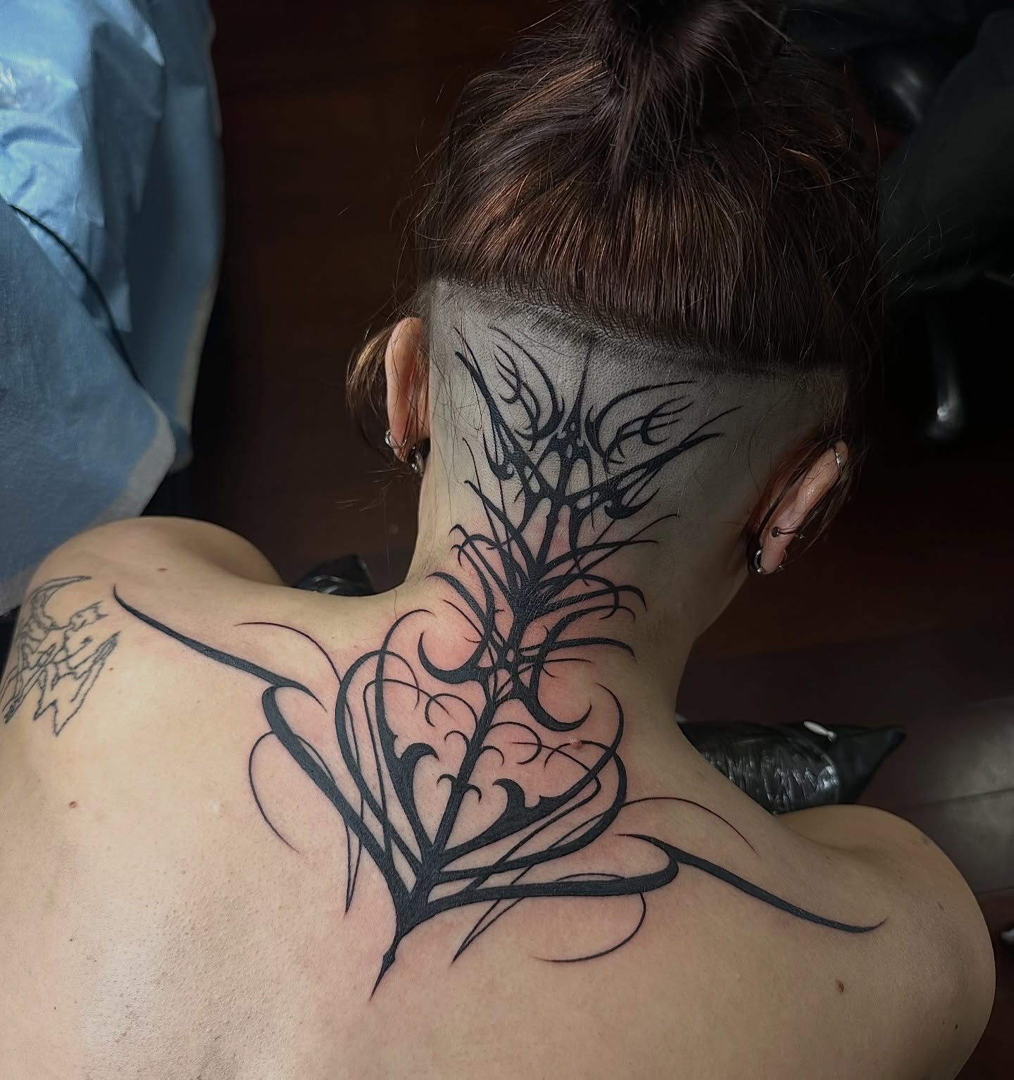 Abstract plant blackwork tattoo on the neck by sechi