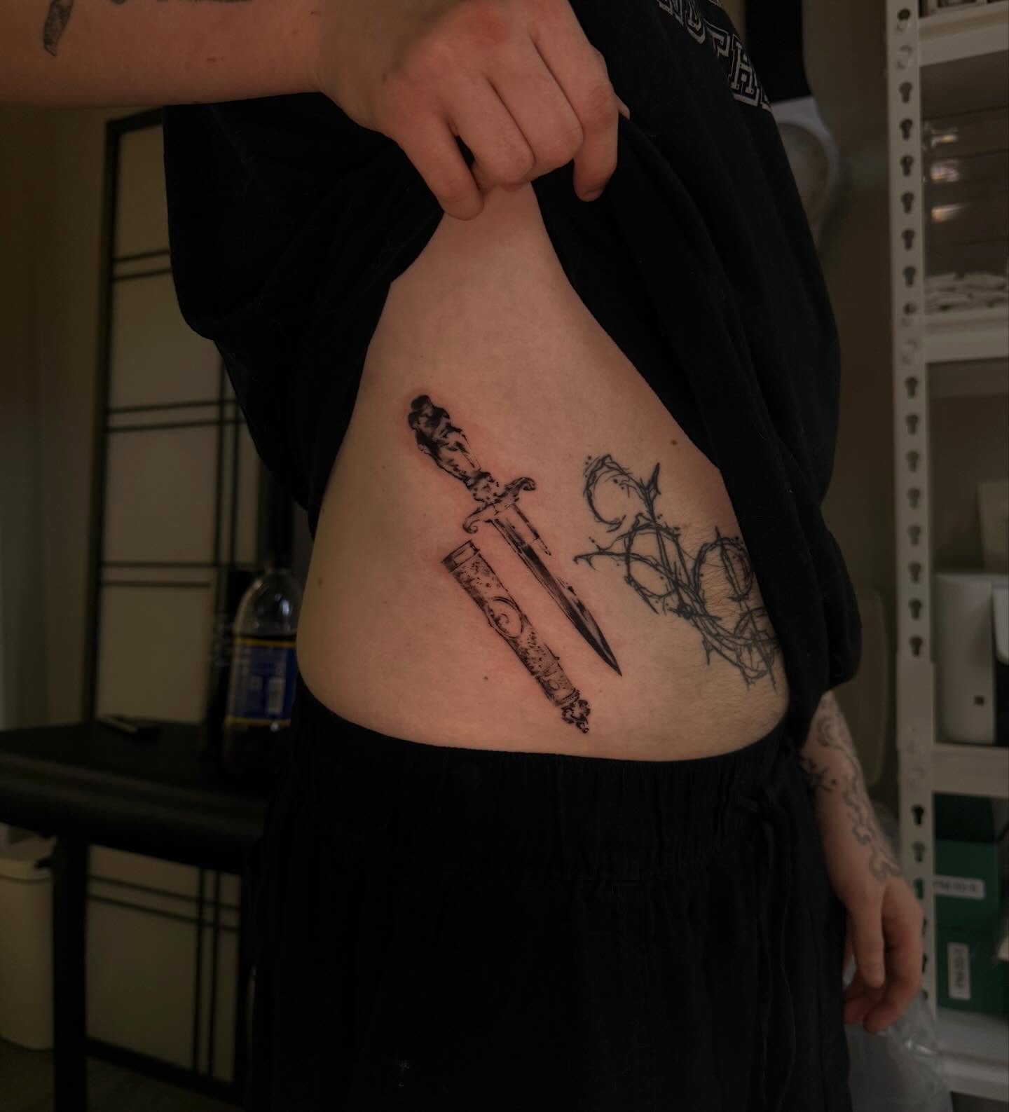 Sword and dagger black and grey tattoo on the ribs by sanjai