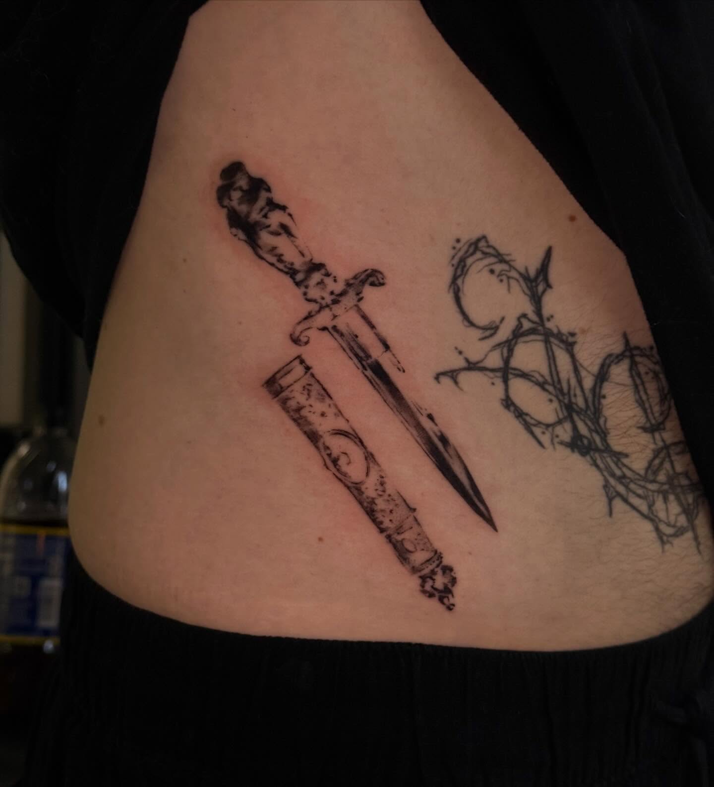 Sword and rose black and grey tattoo on the ribs by sanjai