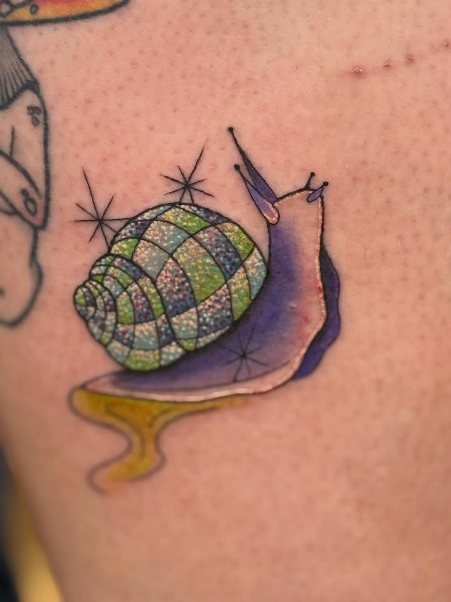Snail watercolor tattoo on the forearm by Serenity Mullins