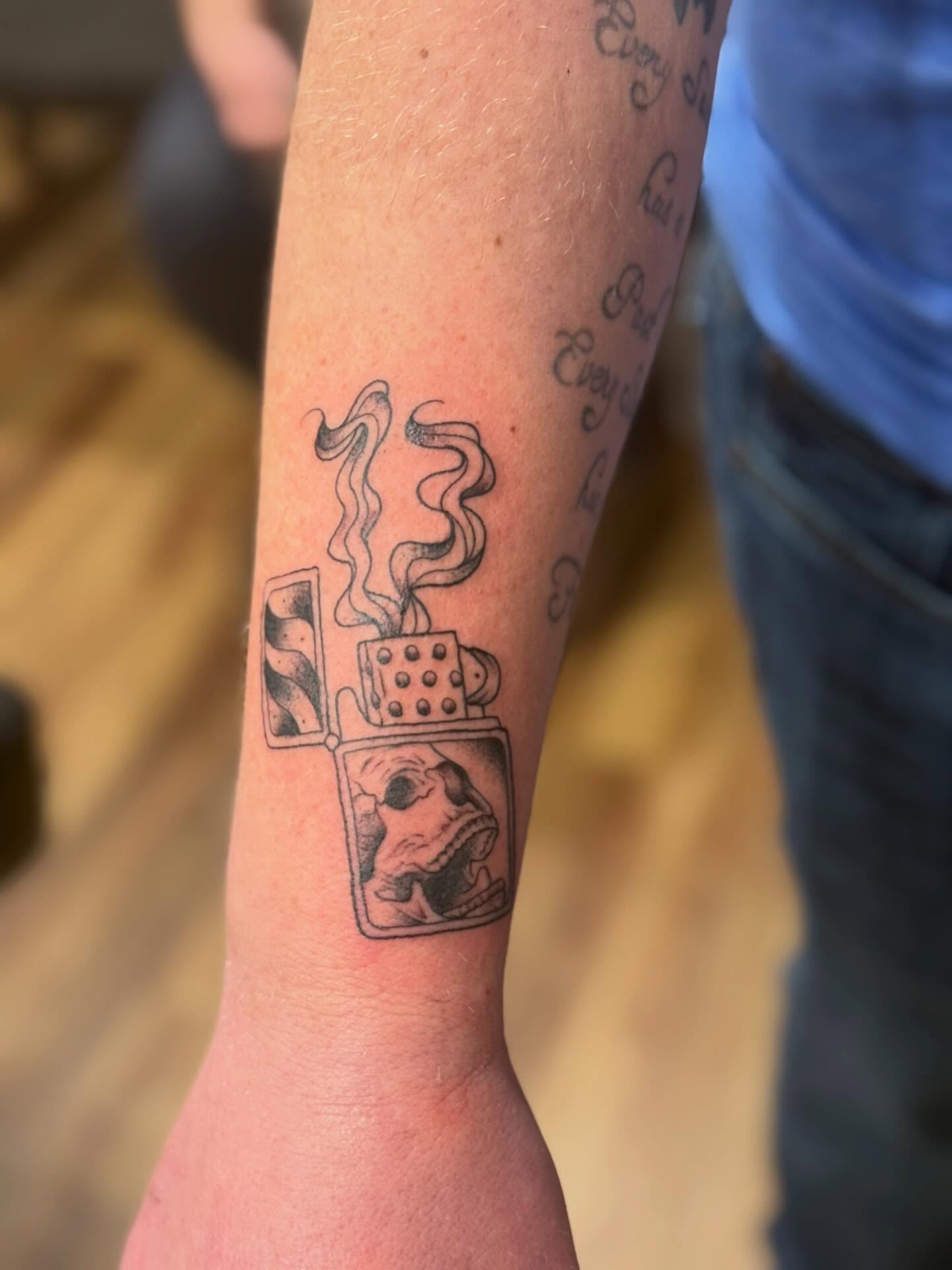 Zippo lighter with skull black and grey tattoo on the forearm by Serenity Mullins