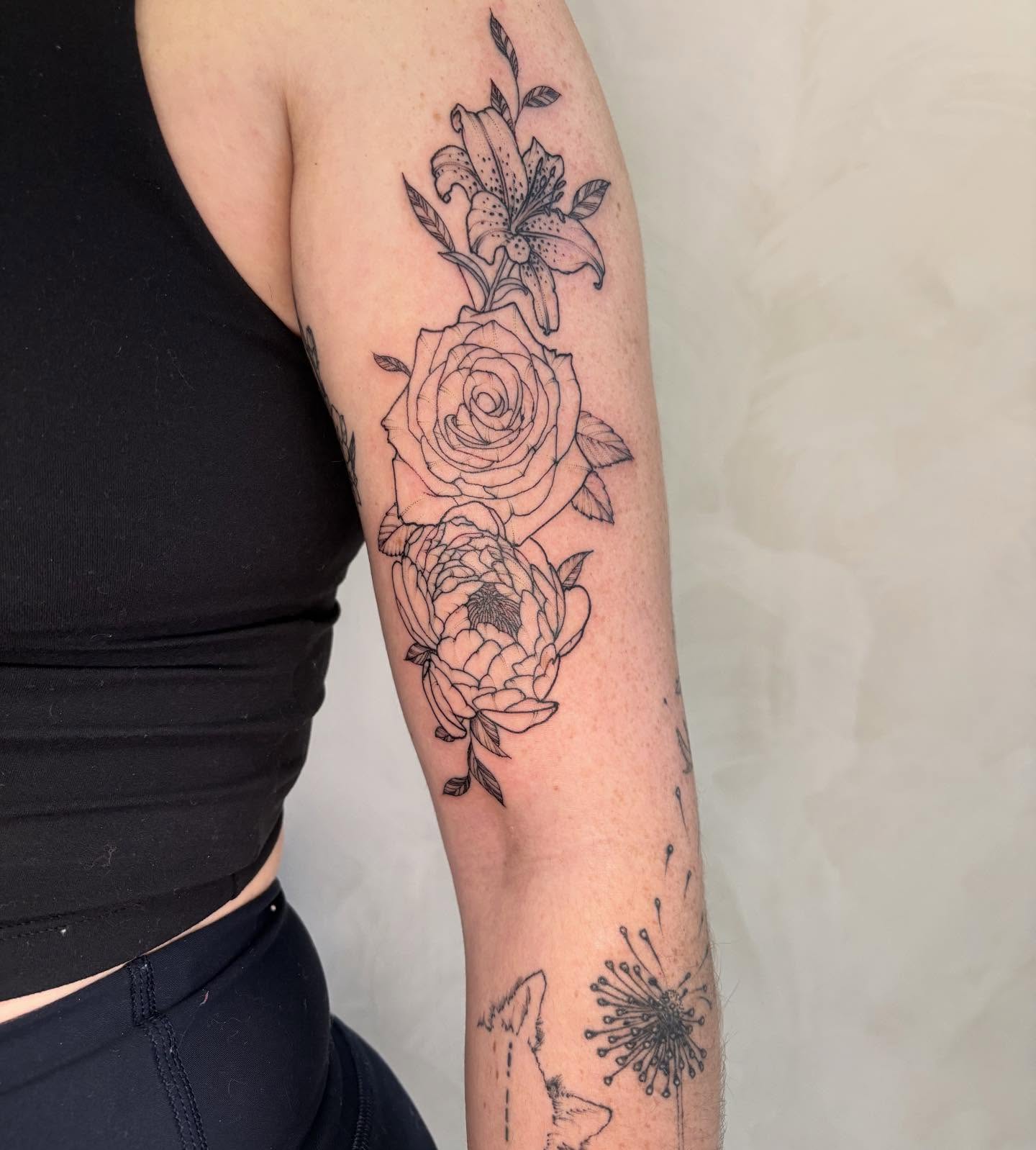 Floral arrangement black and grey tattoo on the forearm by Dallas Davis