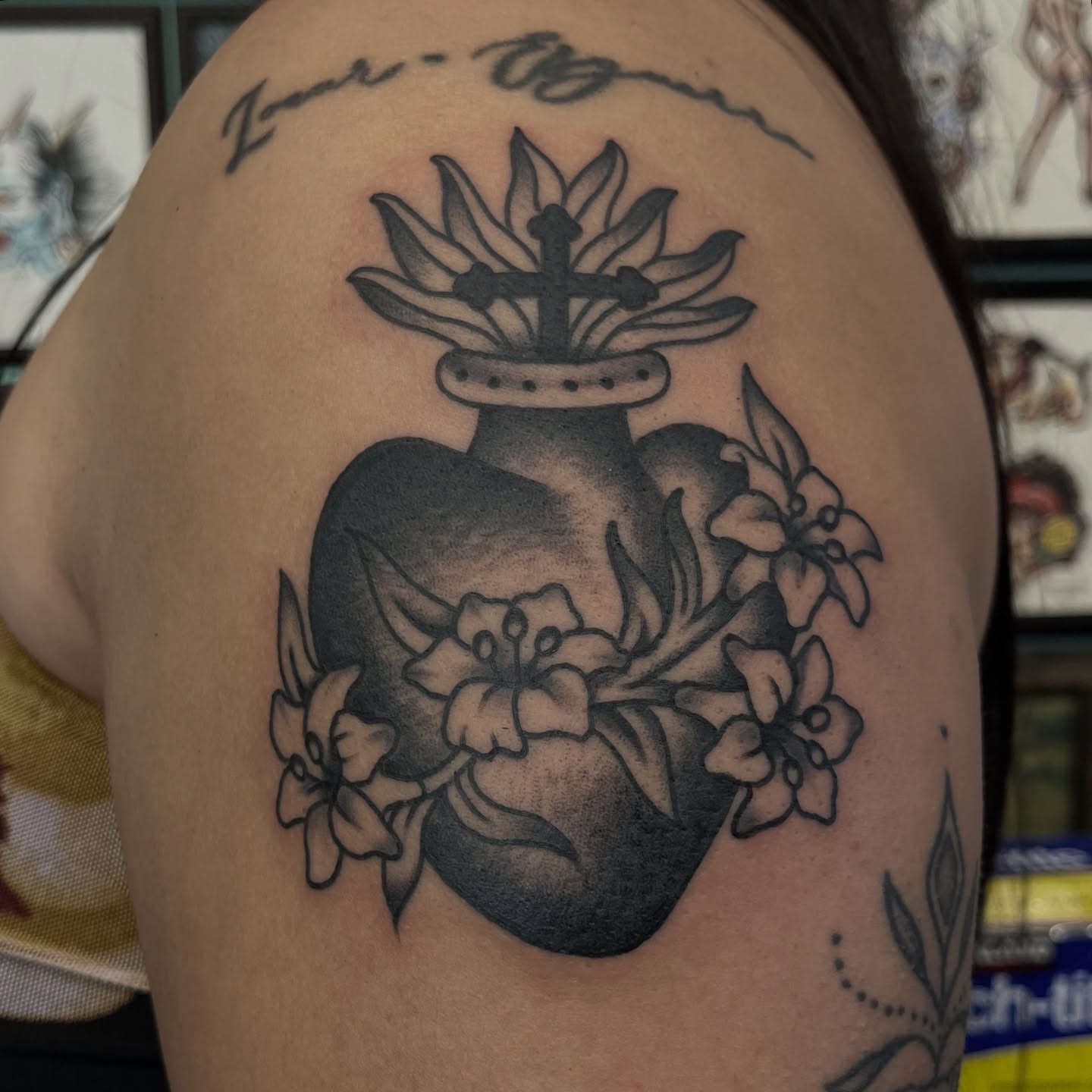 Heart with cross and flowers black and grey tattoo on the shoulder by Jeff Riley ✞