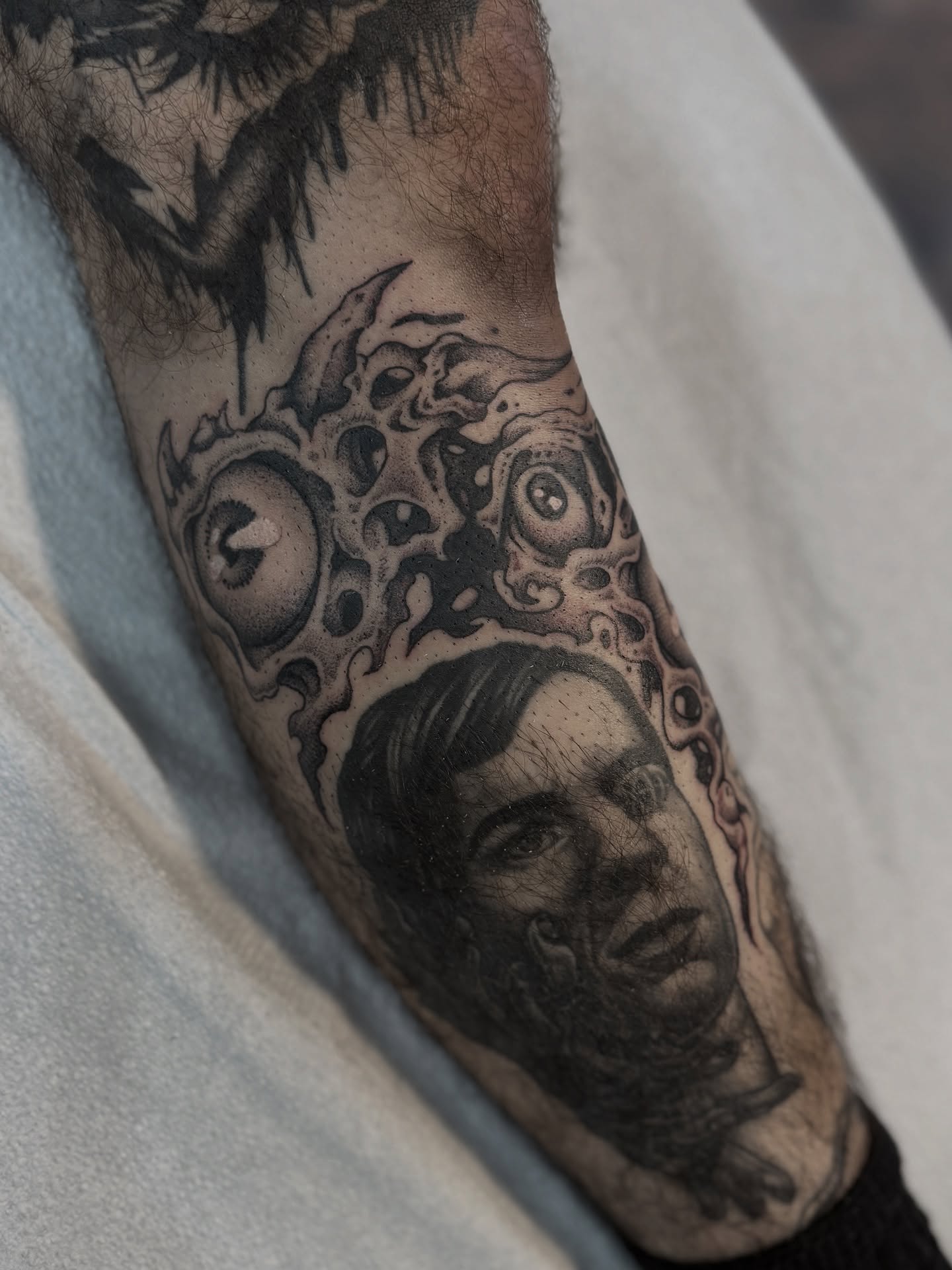 Portrait with surreal background surrealism tattoo on the forearm by Andrew