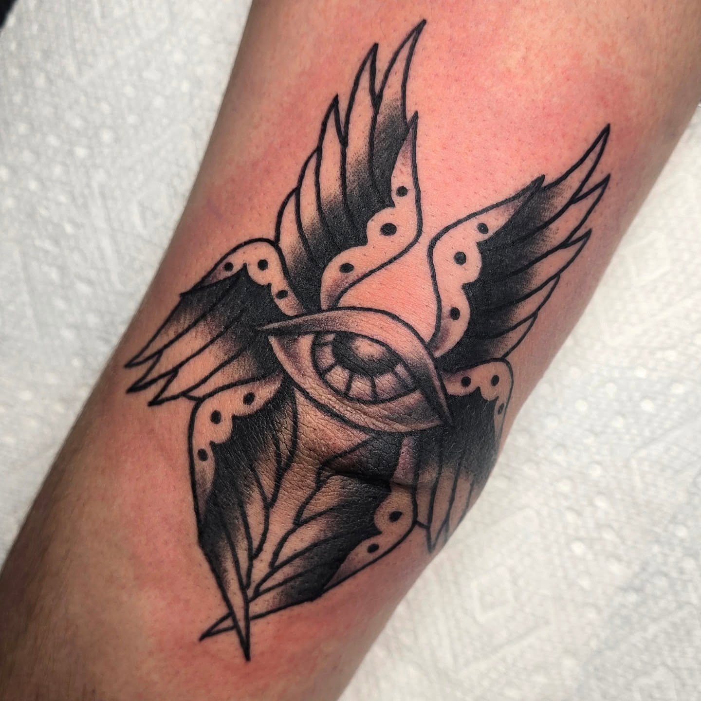 Eye with wings black and grey tattoo on the forearm by A. Teixeira, Los Angeles, California
