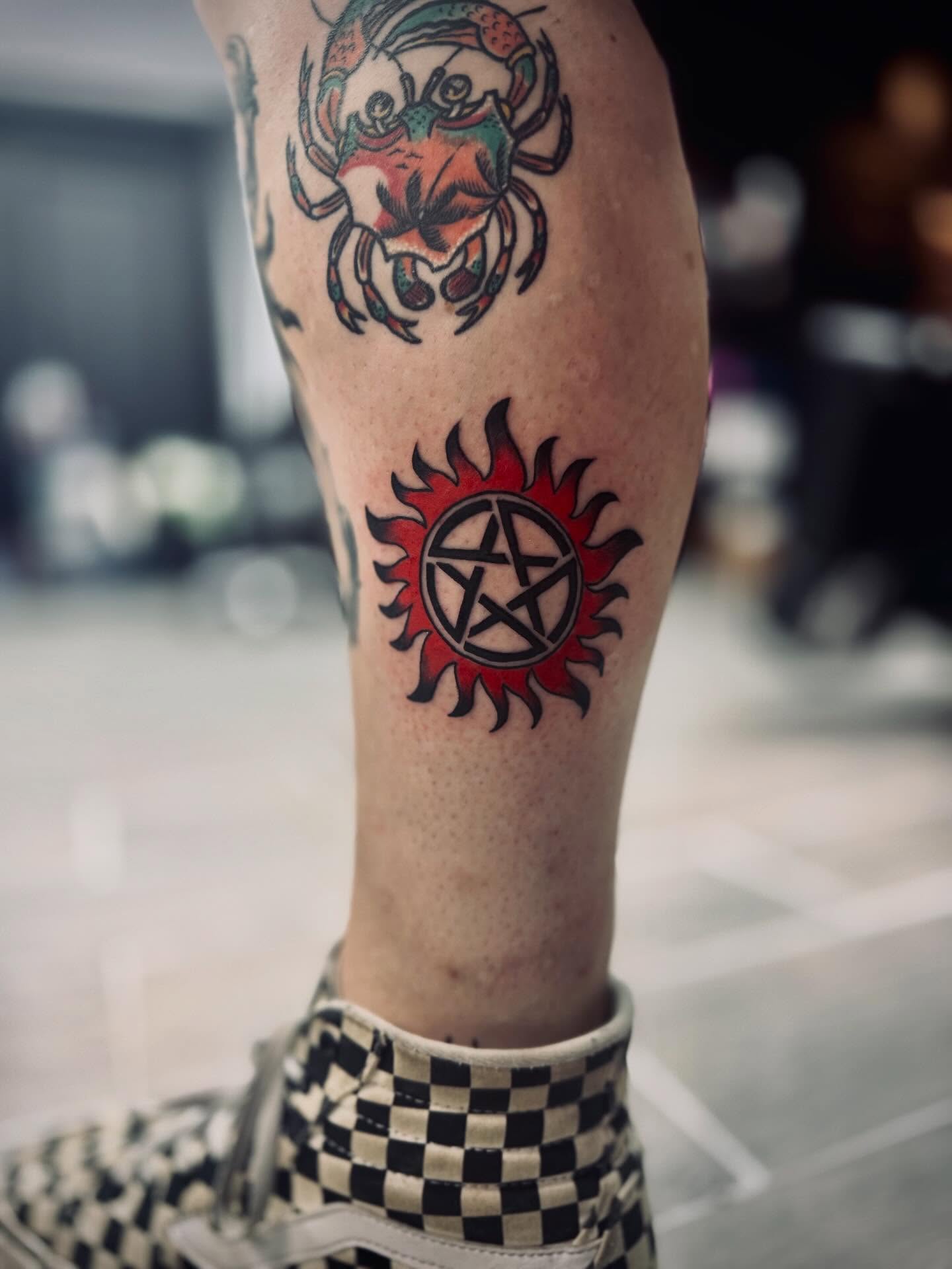 Sun and pentagram American traditional tattoo on the leg by Katelyn Arnold