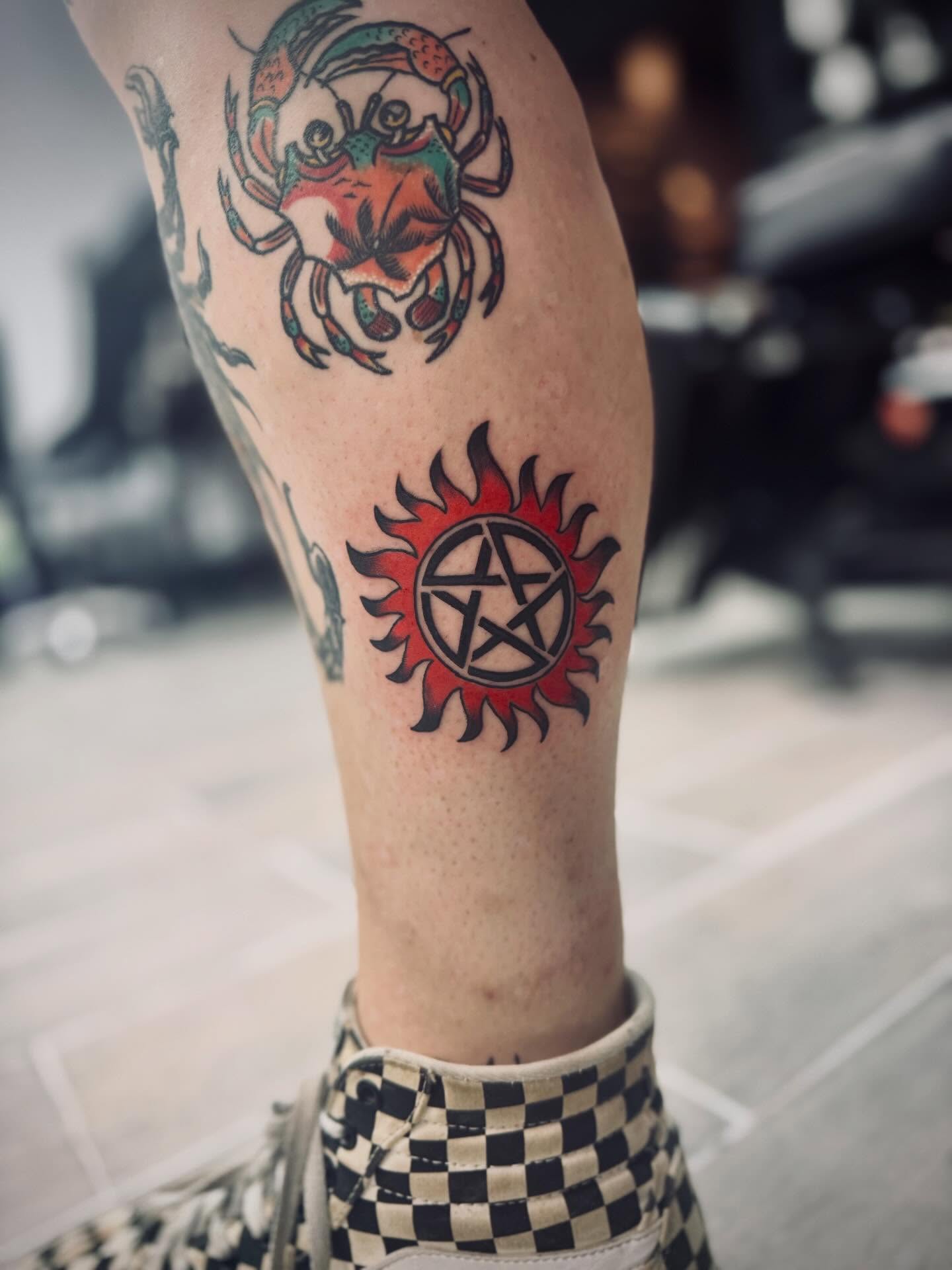 Crab and sun symbol American traditional tattoo on the forearm by Katelyn Arnold