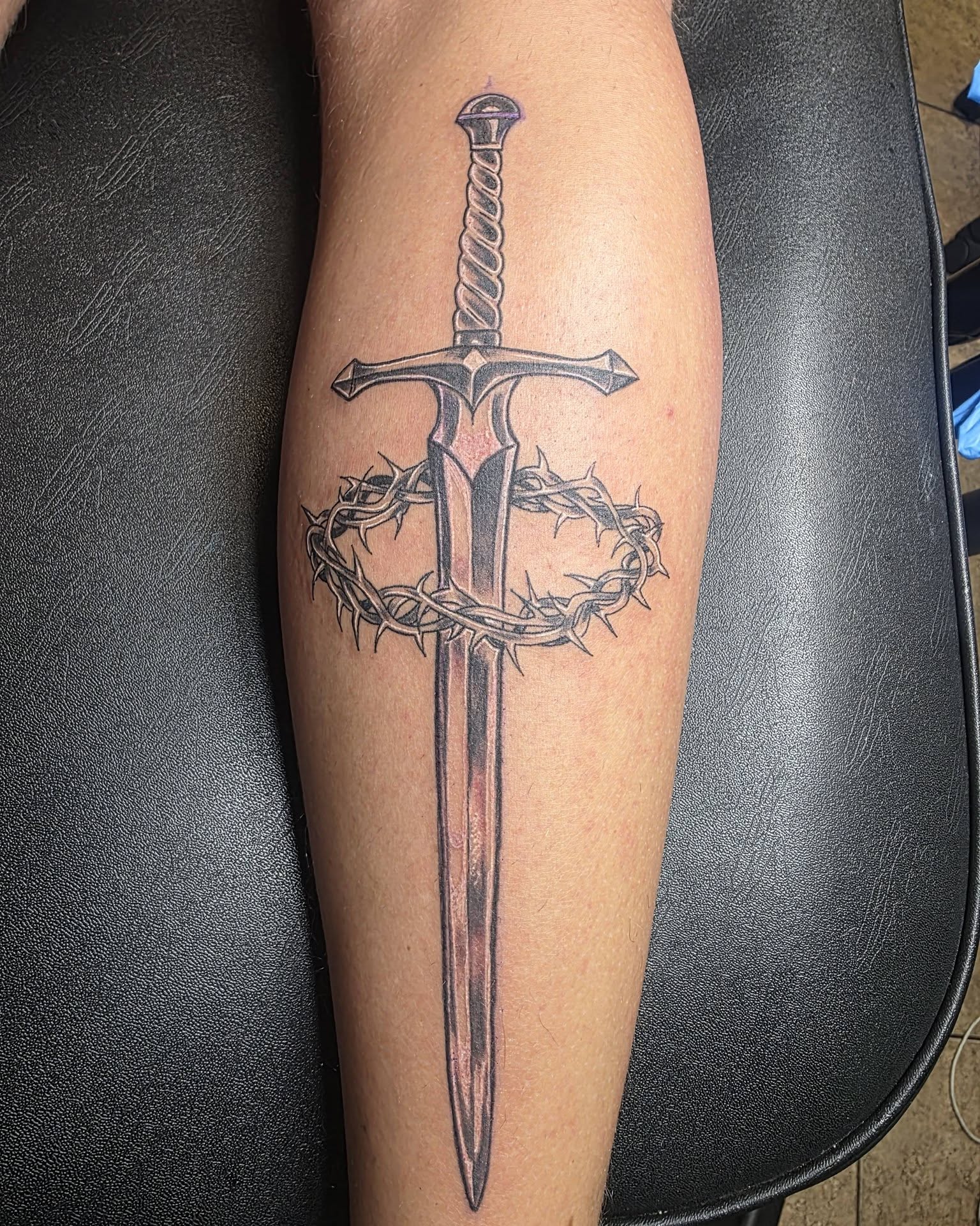 Sword and crown of thorns black and grey tattoo on the forearm by Jessica DarkRabbit