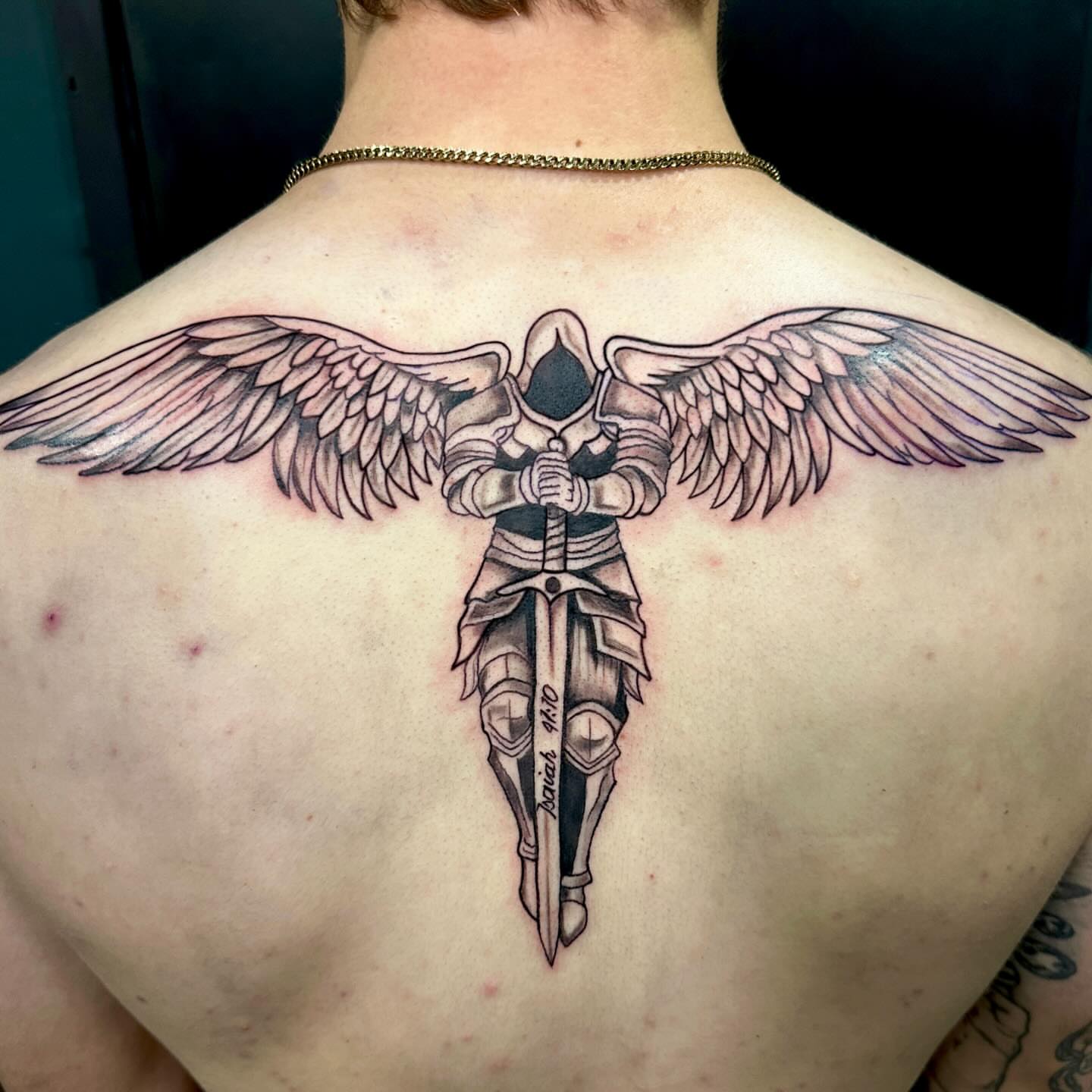 Winged knight black and grey tattoo on the back by Mika'la Berry