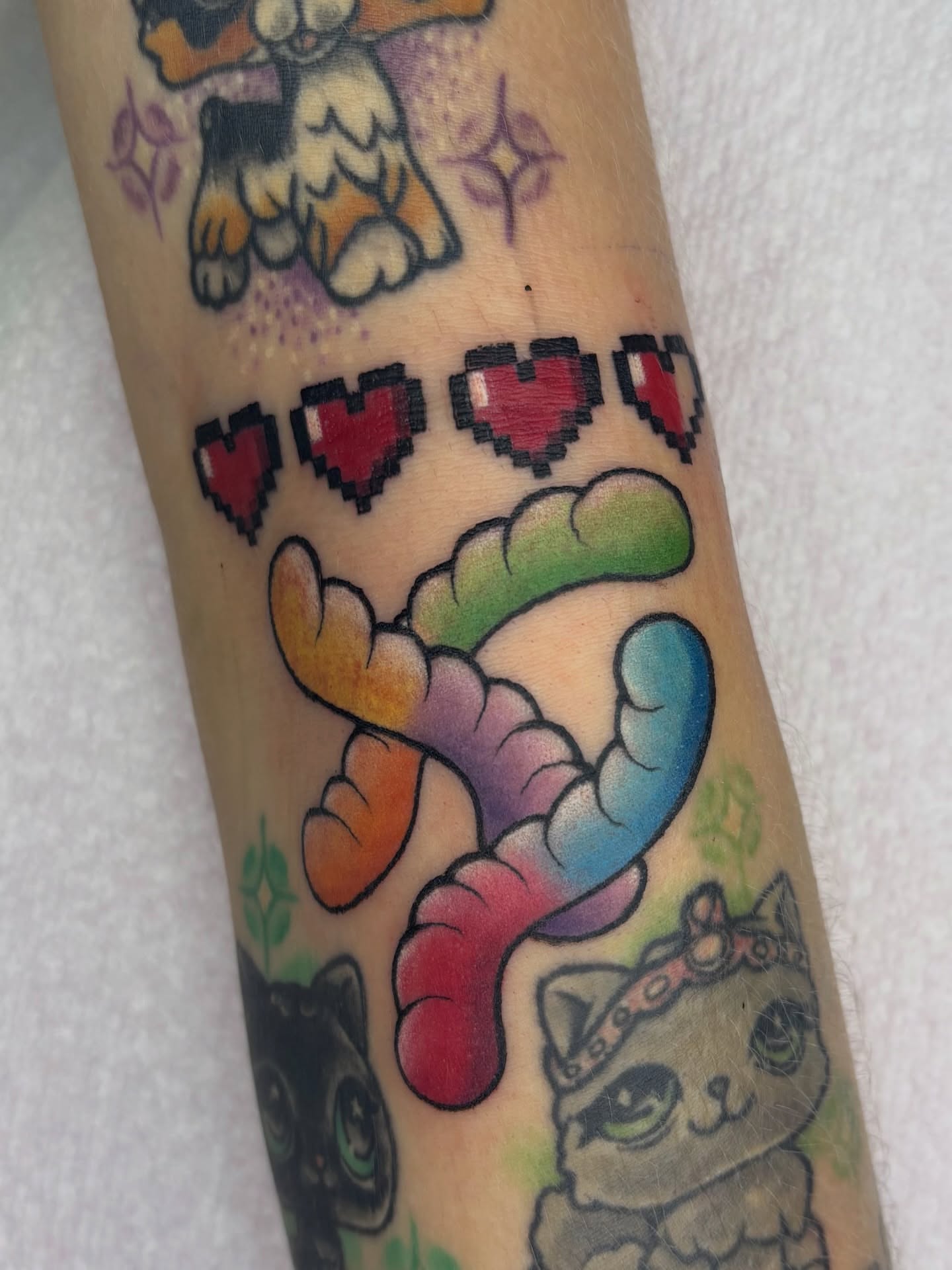 Pixelated hearts and cats dotwork tattoo on the forearm by Lilac Rose