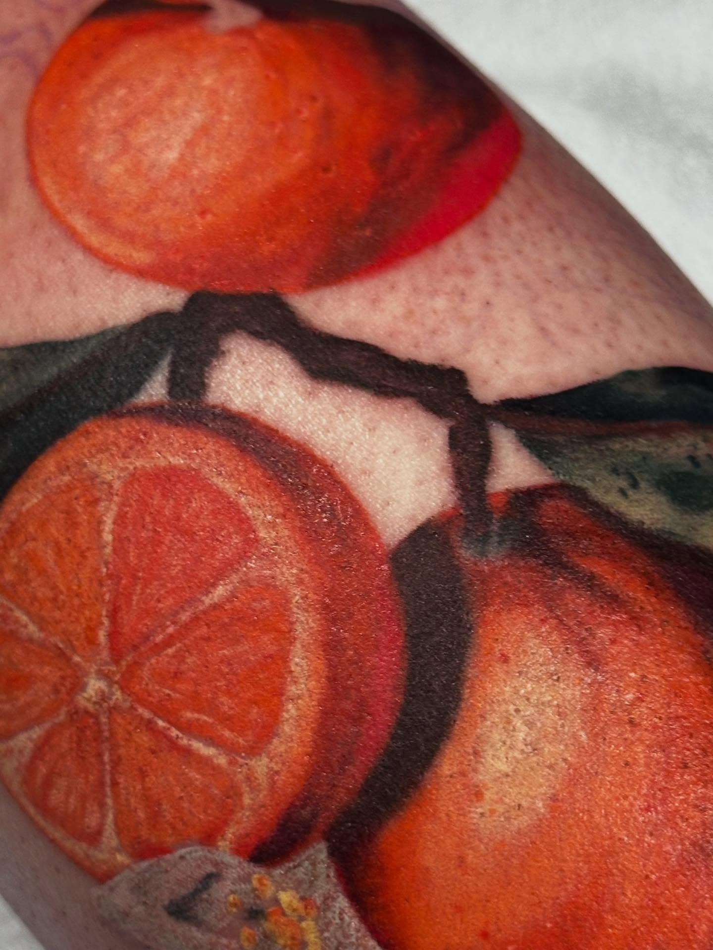 Oranges realism tattoo on the upper arm by Colbylee Tattoo Norwich