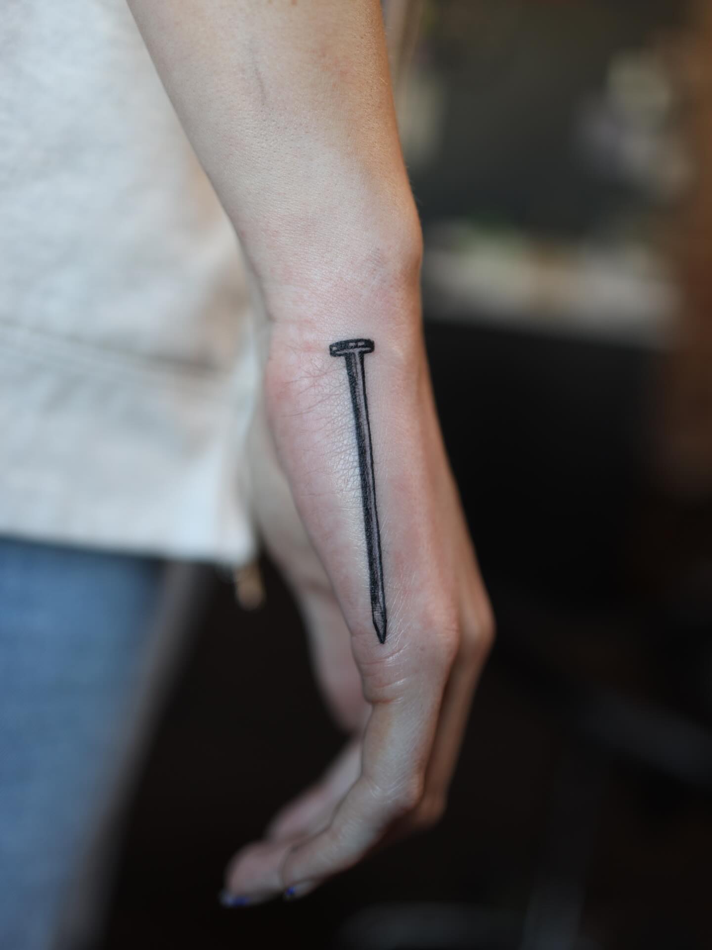 Nail black and grey tattoo on the forearm by morgan purcey