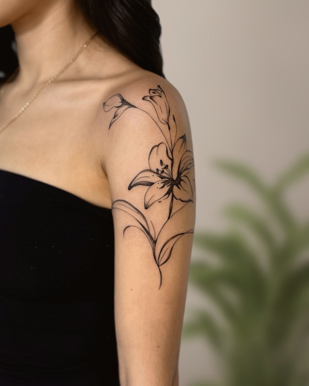 Lily black and grey tattoo on the shoulder by Ingrid Rojas