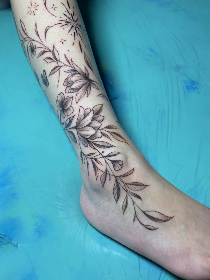 Floral arrangement black and grey tattoo on the calf by Nikko