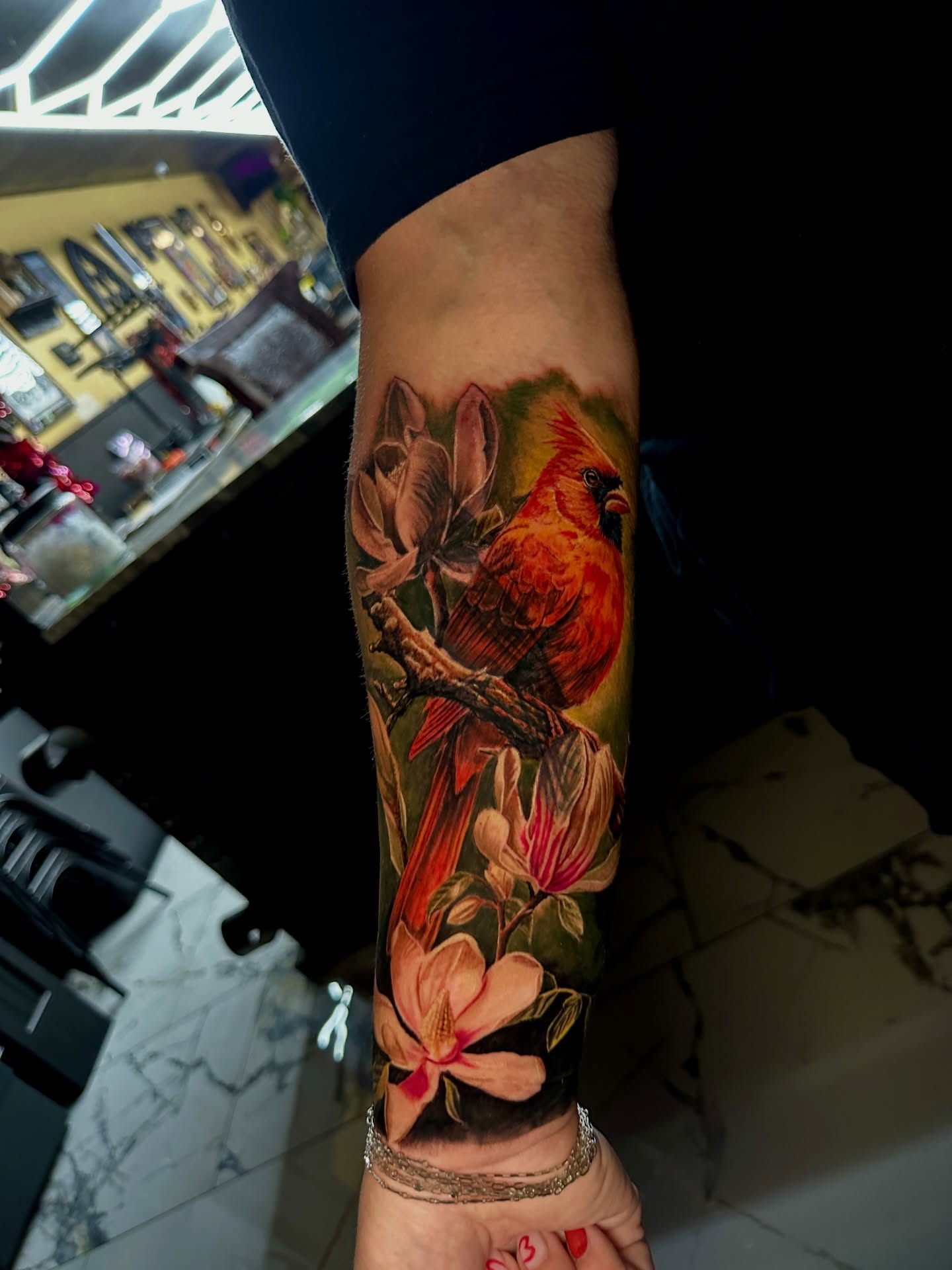 Cardinal and magnolia realism tattoo on the forearm by Billy Harris