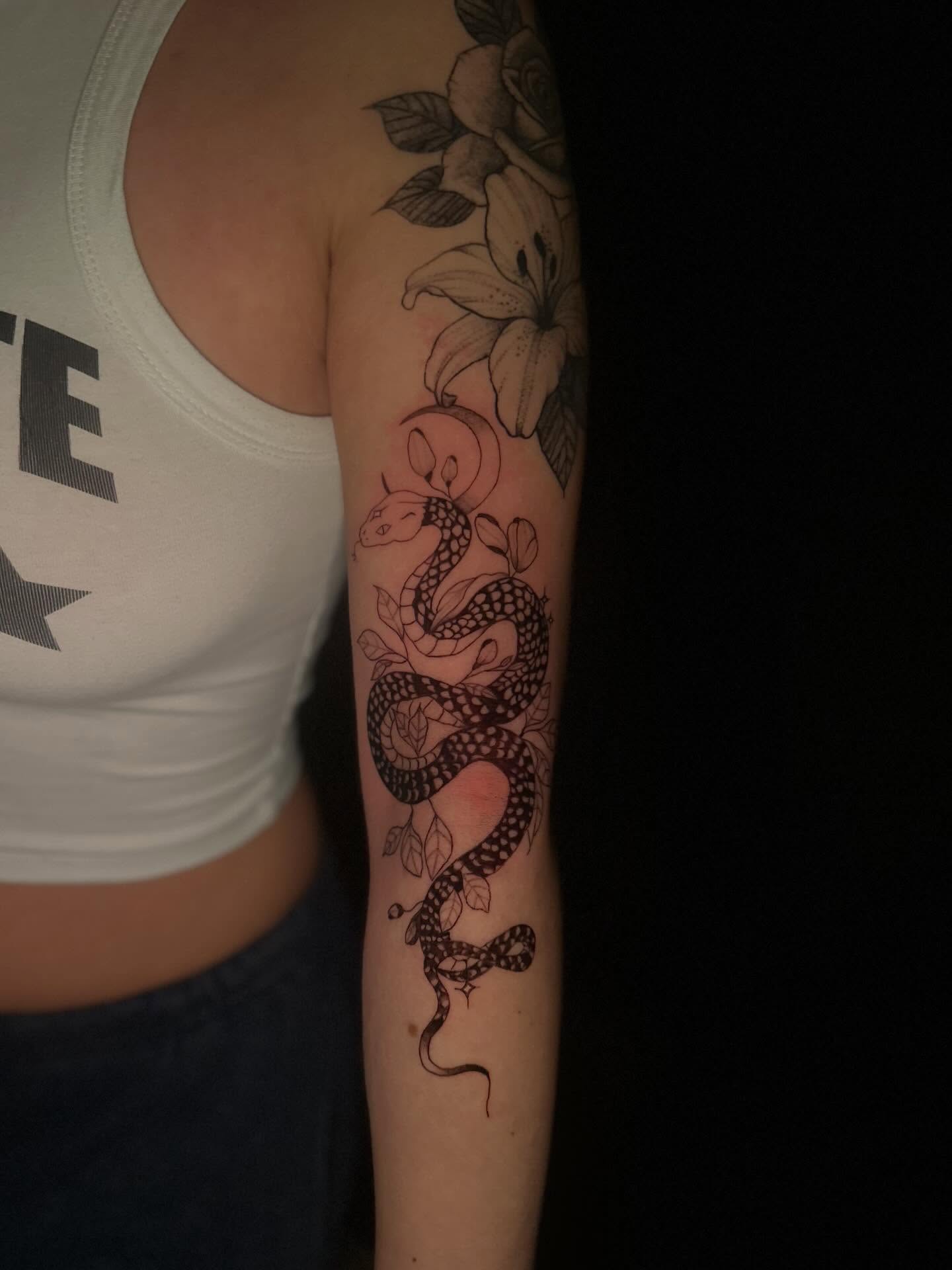 Snake and flowers black and grey tattoo on the forearm by Cherry Tats🍒