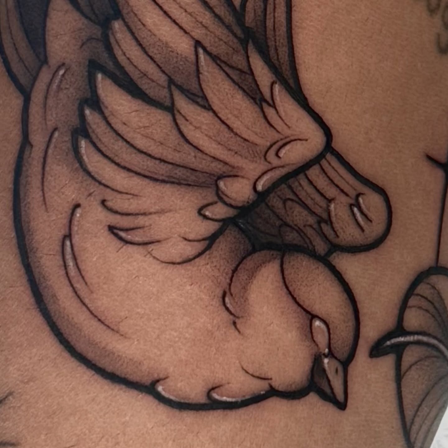 Bird black and grey tattoo on the upper arm by Gabrieli Folha