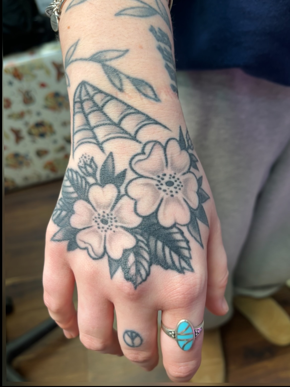 Flowers American traditional tattoo on the hand by Macy Bird