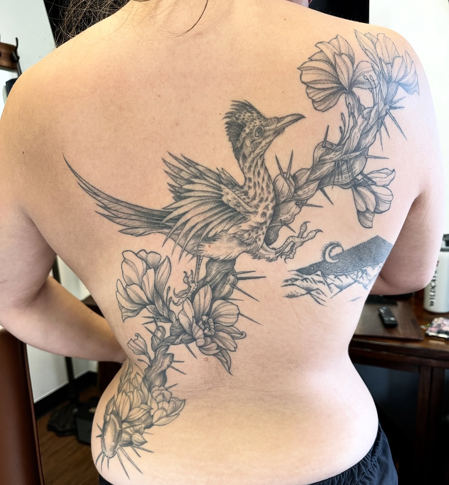 Bird and cactus flowers realism tattoo on the back by Robert McCollum