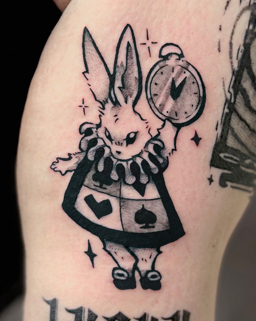 White rabbit black and grey tattoo on the upper arm by Kal