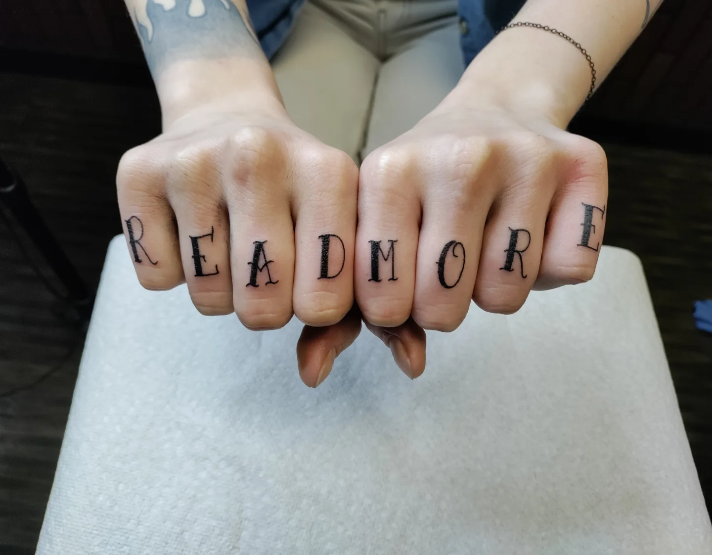 READMORE lettering script tattoo on the hand by Kennedy Jones, Lee's Summit, Missouri