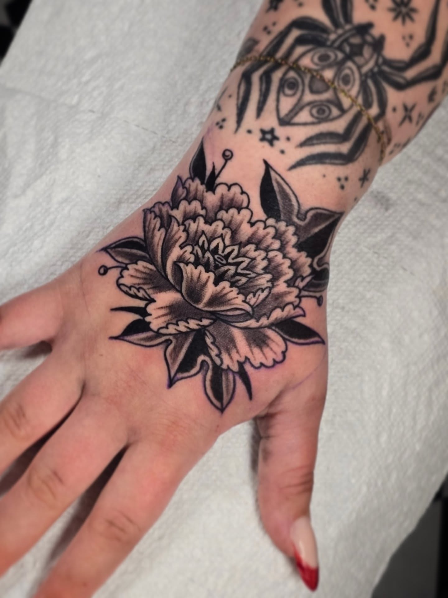 Peony American traditional tattoo on the hand by Aaron Dor