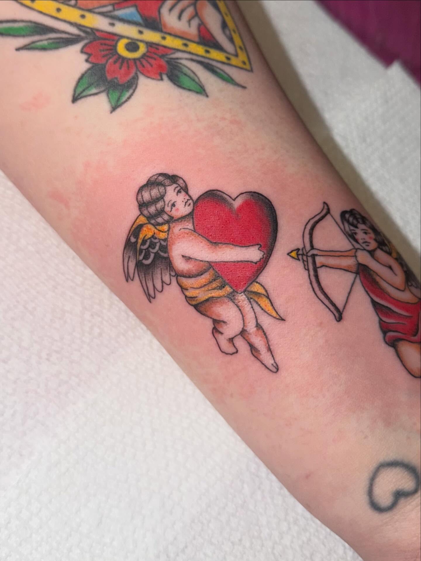 Cherub holding heart American traditional tattoo on the forearm by Alaska ⚜️