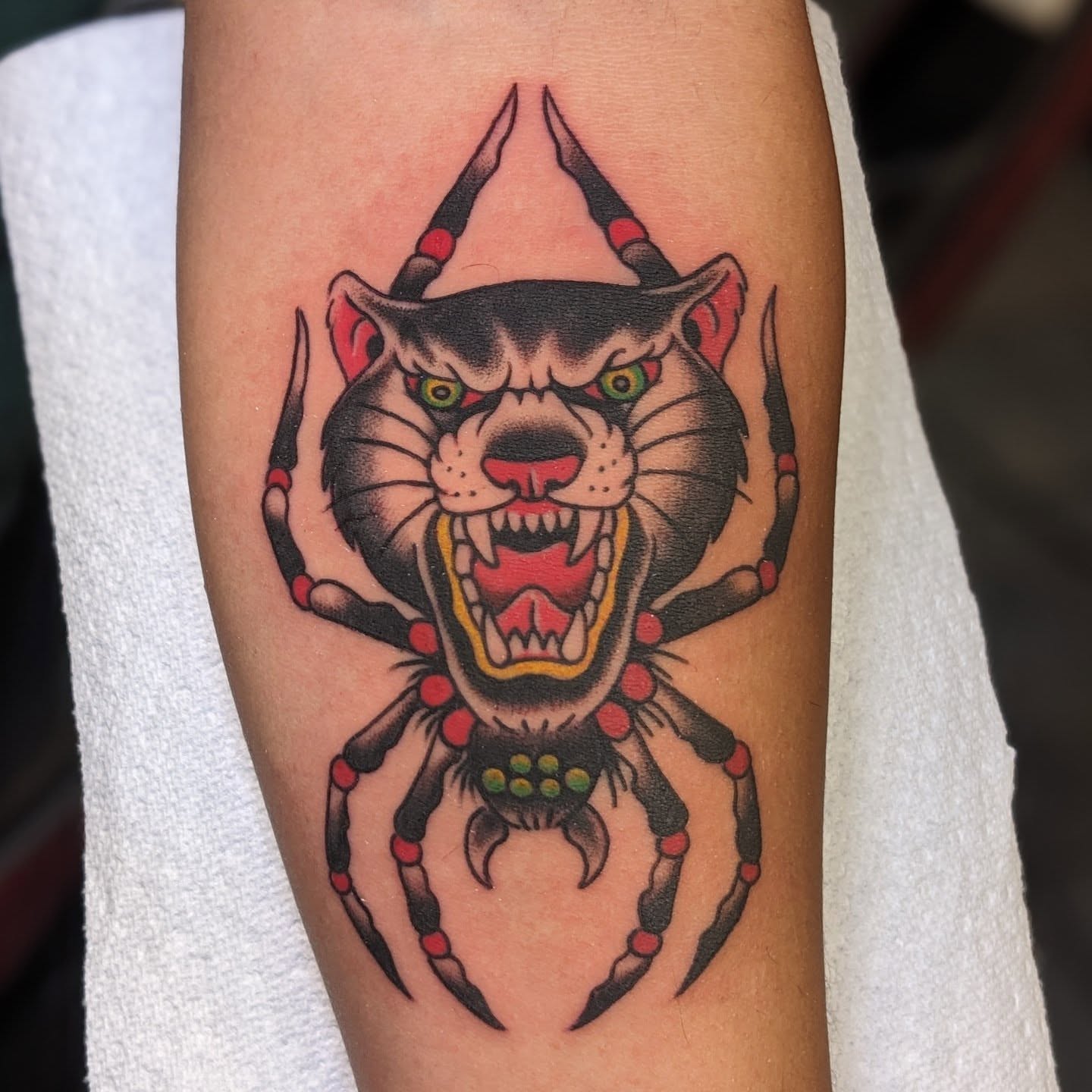 Angry cat spider American traditional tattoo on the forearm by Matt Simmonds