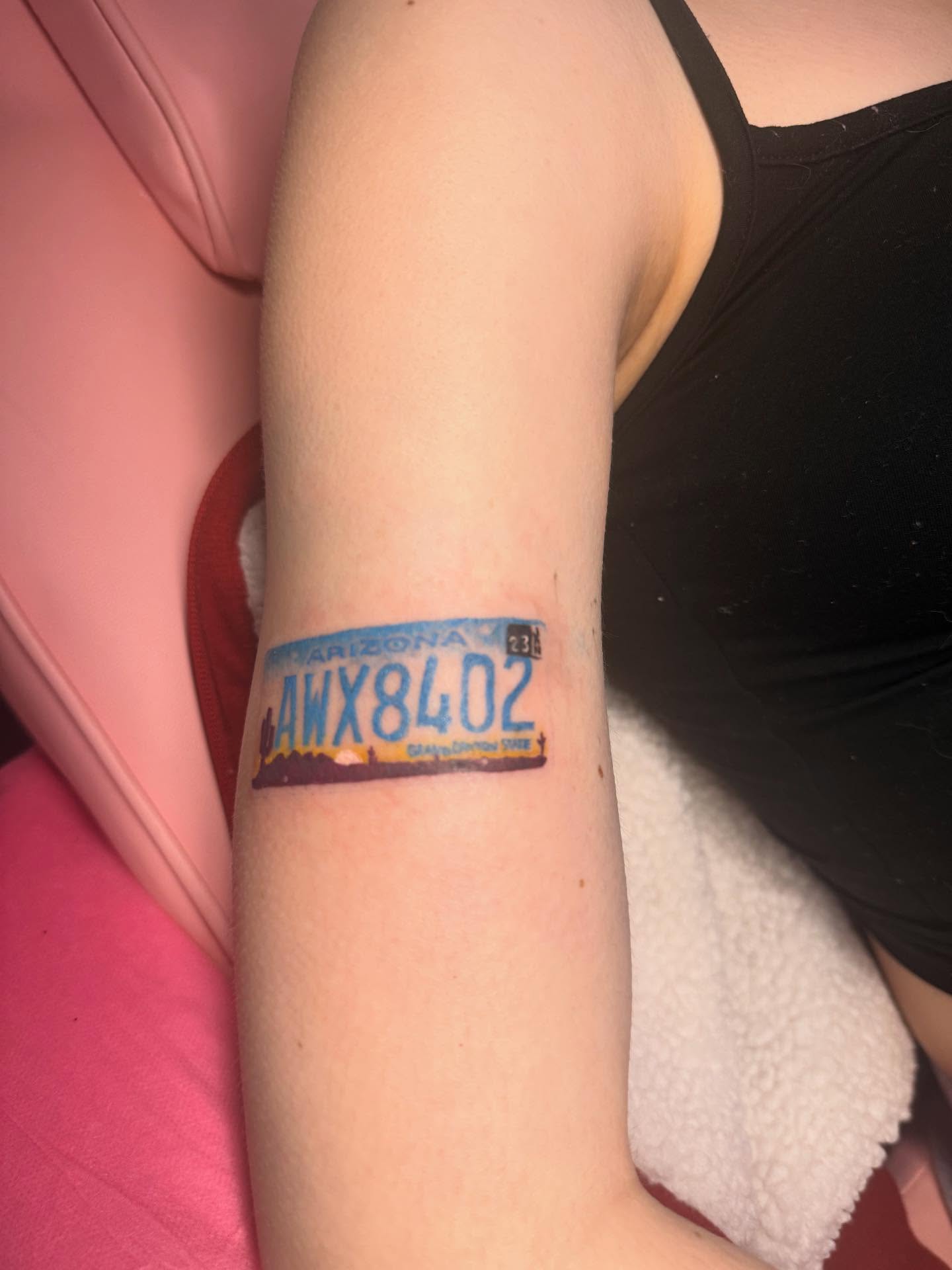 Arizona license plate black and grey tattoo on the forearm by Tattoos by Santos
