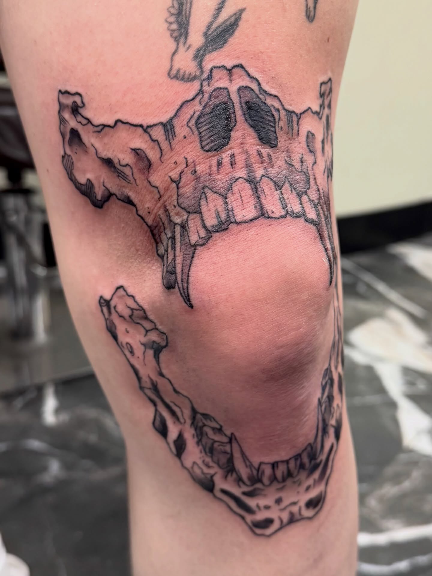 Skull black and grey tattoo on the thigh by Sonder