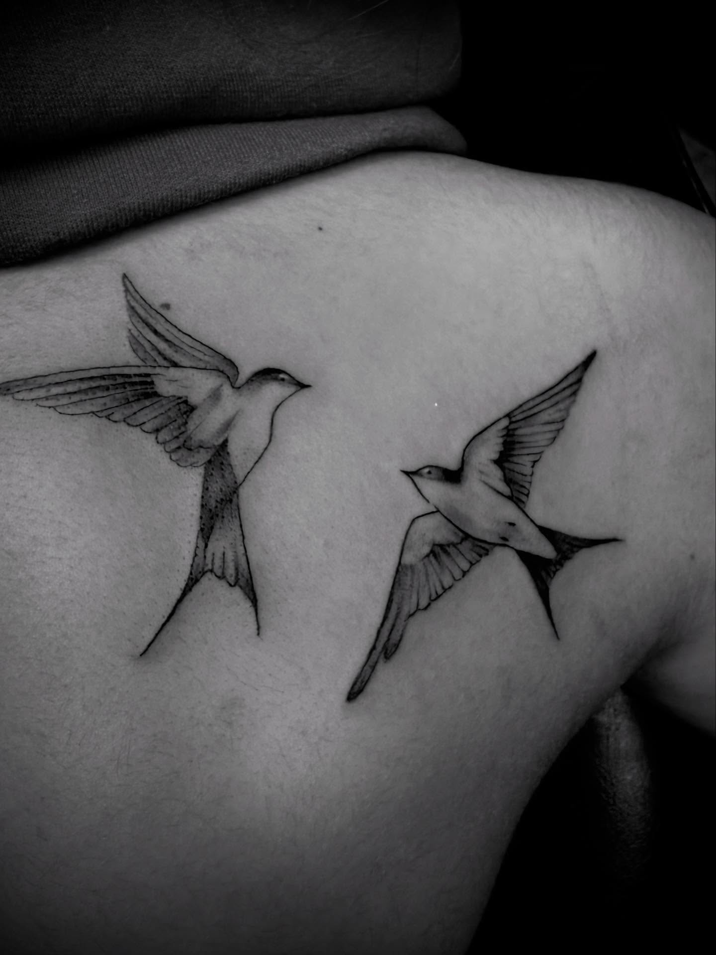 Swallows black and grey tattoo on the shoulder by Jameson William Cowan