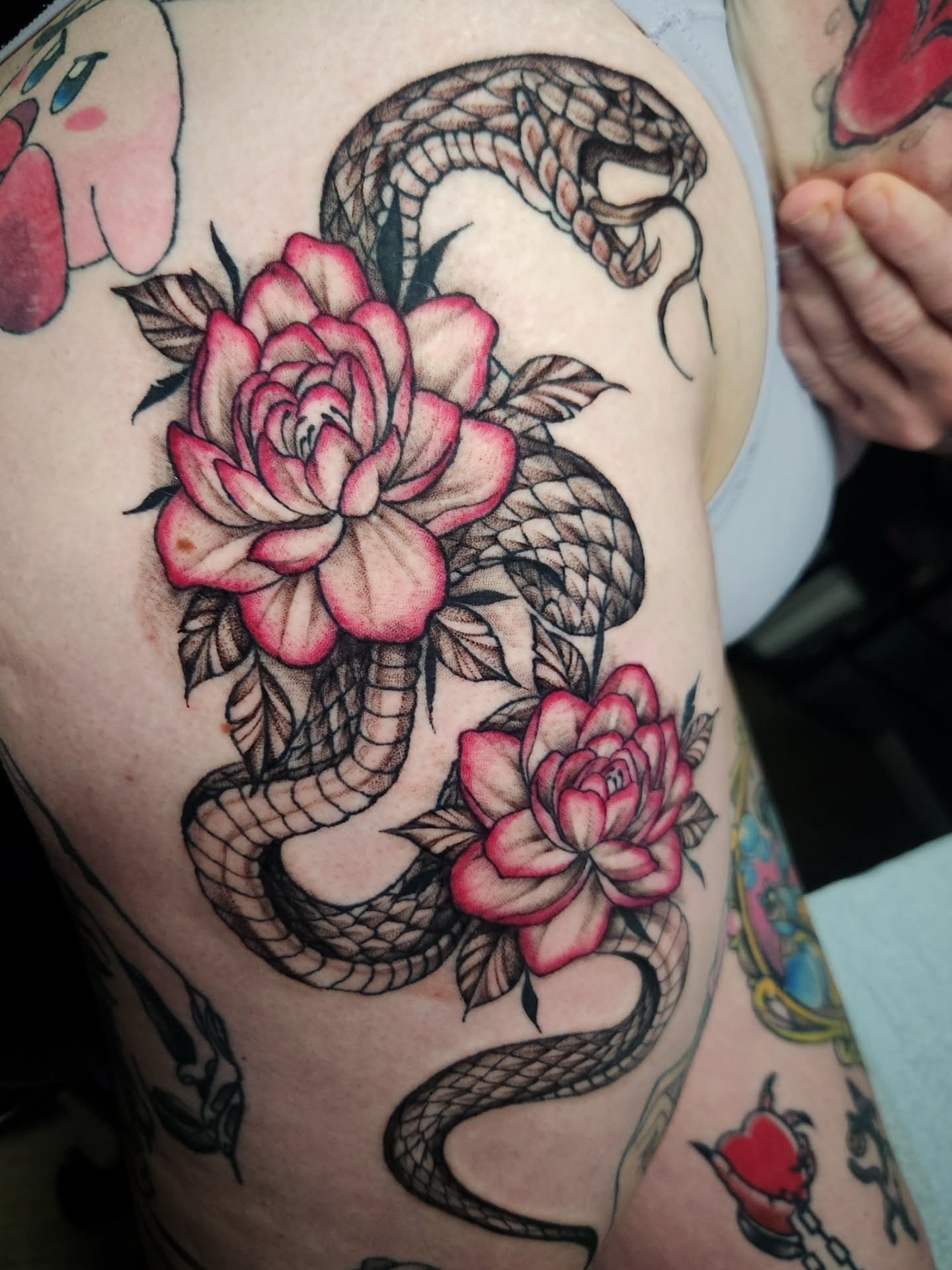Snake and peony American traditional tattoo on the thigh by Abby Renteria