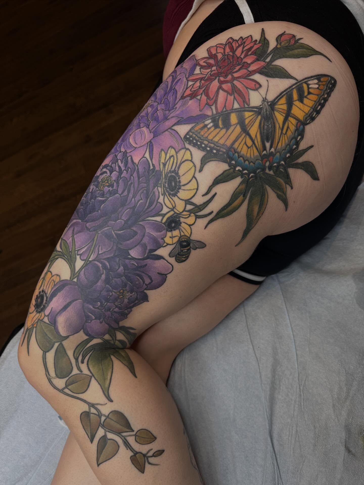 Butterfly and flowers realism tattoo on the thigh by Rachael Shelly