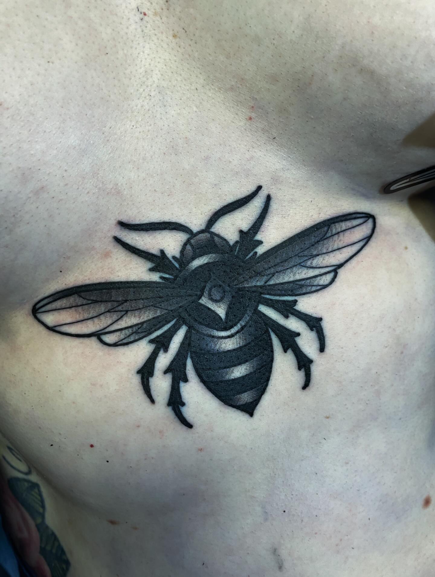 Bee black and grey tattoo on the chest by Houston tattoo artist