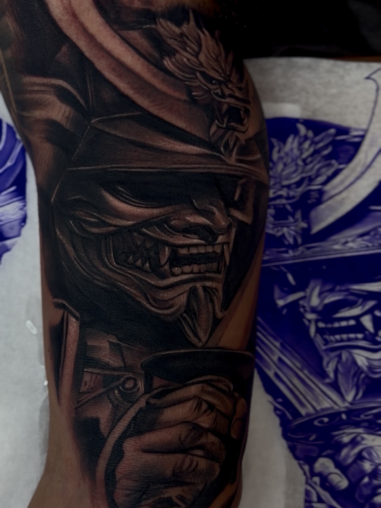 Mask and sword dark realism tattoo on the forearm by Raul Rodriguez