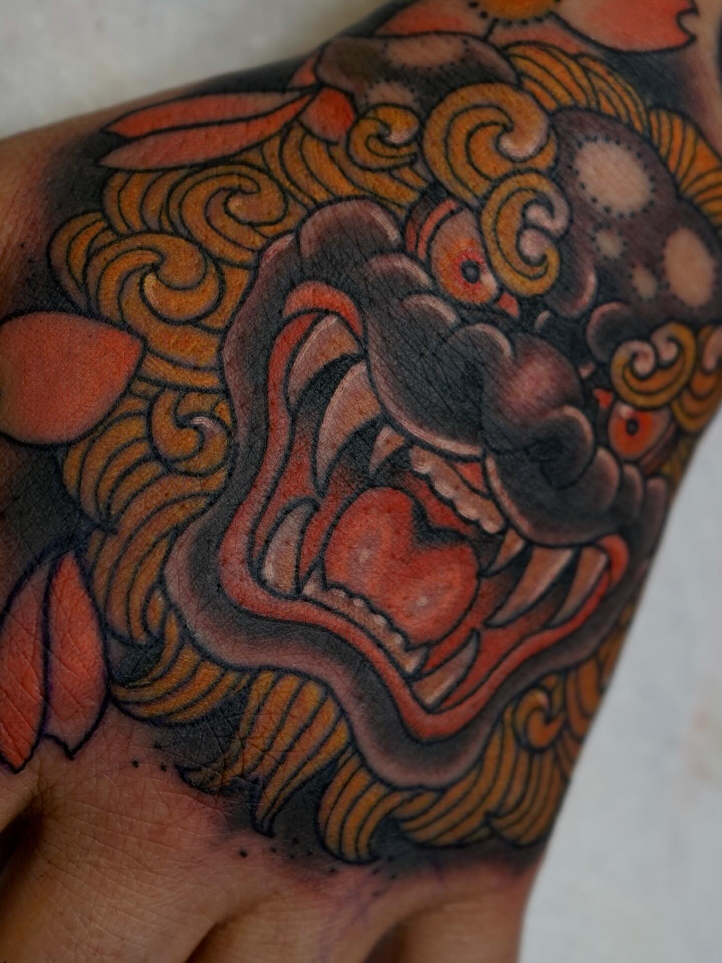 Lion American traditional tattoo on the hand by Tyler Harrington