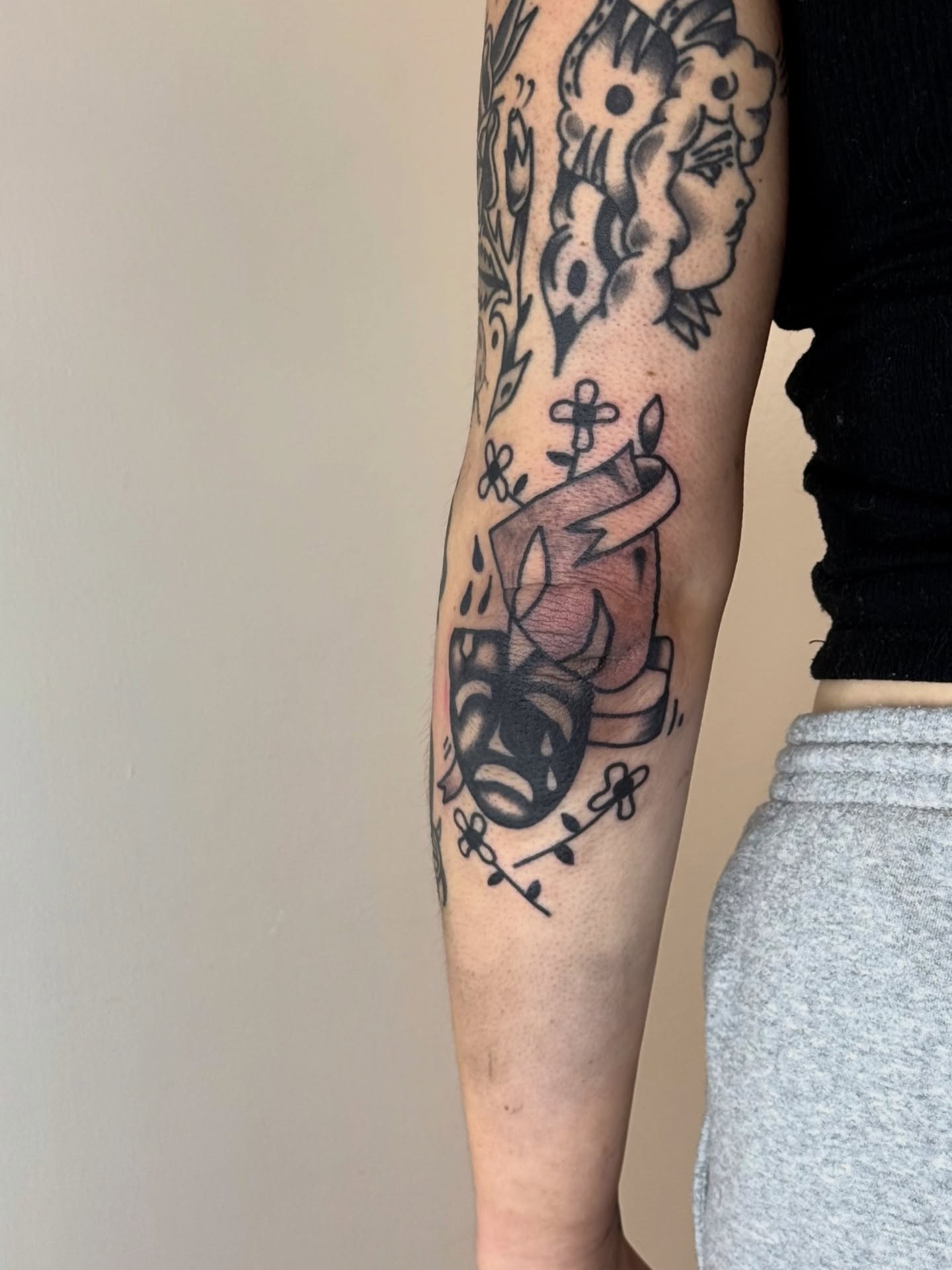 Floral arrangement with candle American traditional tattoo on the forearm by Roman