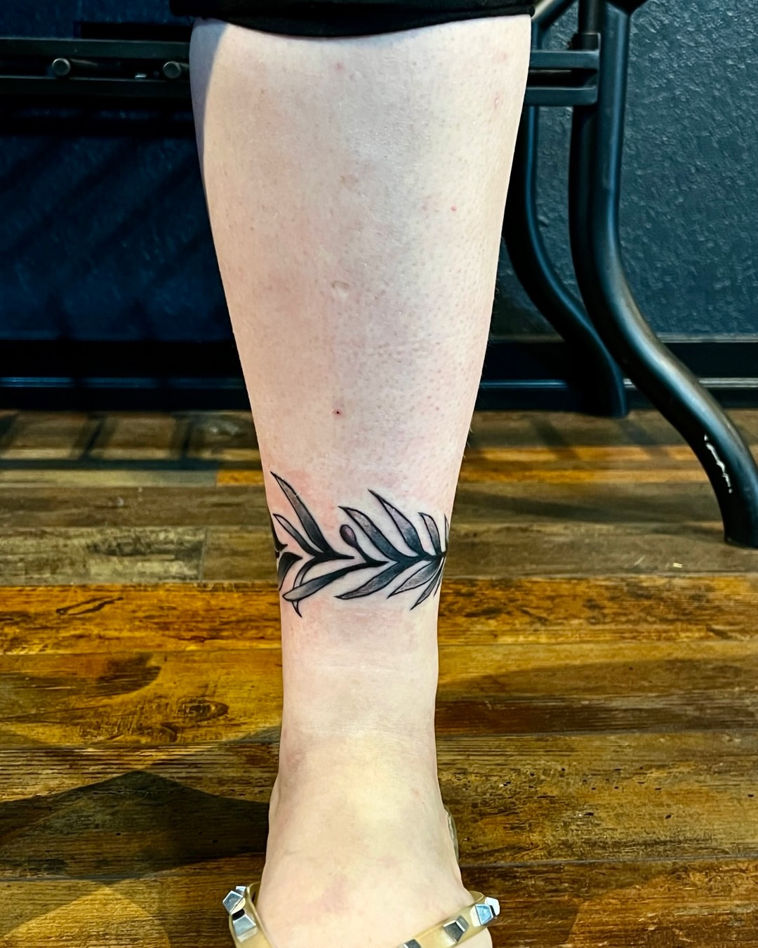 Feather black and grey tattoo on the calf by Deacon Moser
