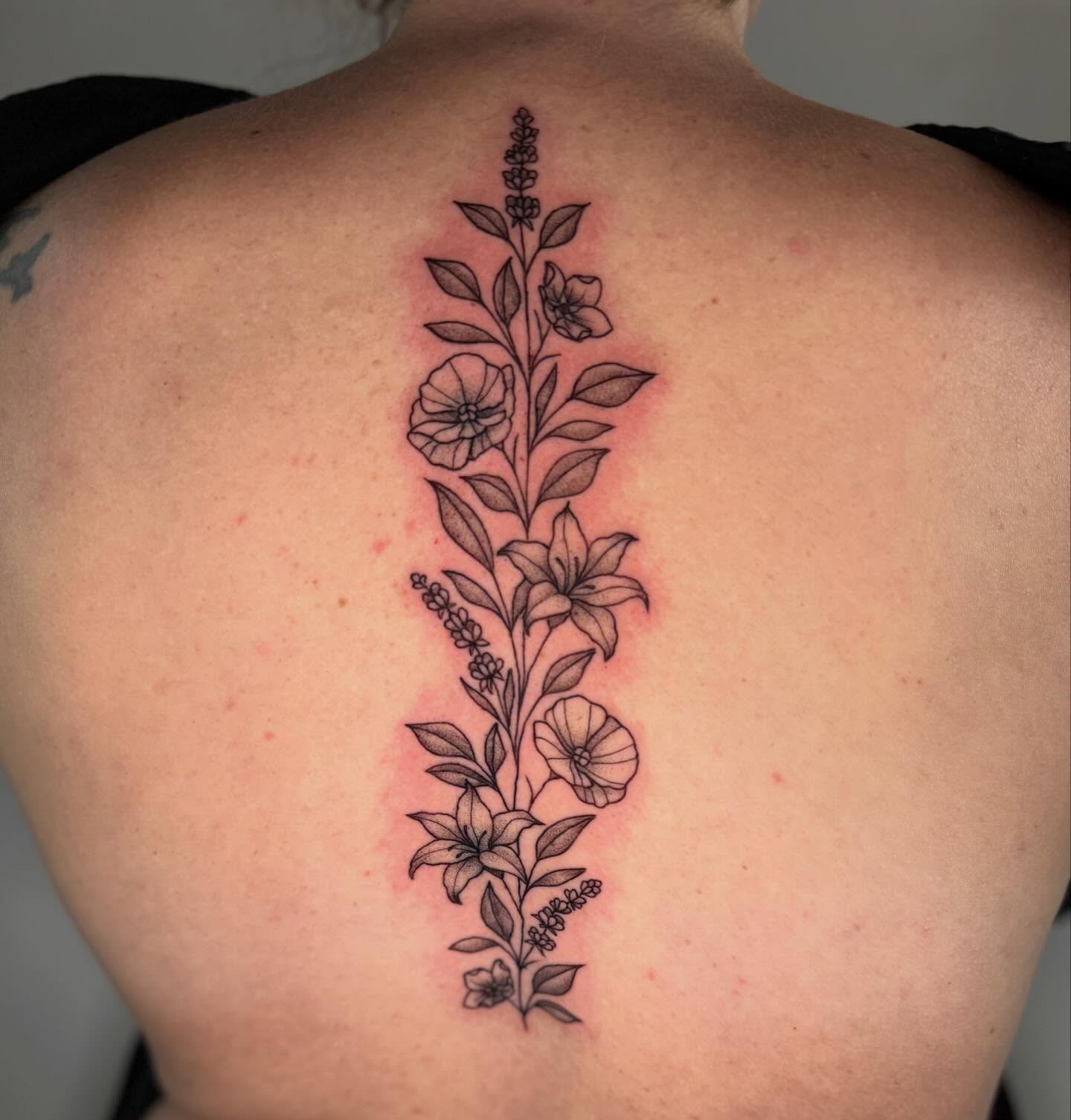 Floral arrangement black and grey tattoo on the back by Felicity