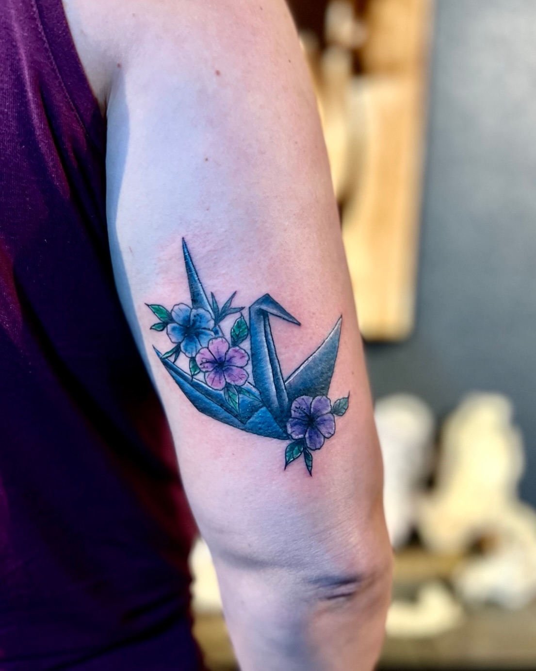 Origami crane and flowers geometric tattoo on the forearm by Deacon Moser